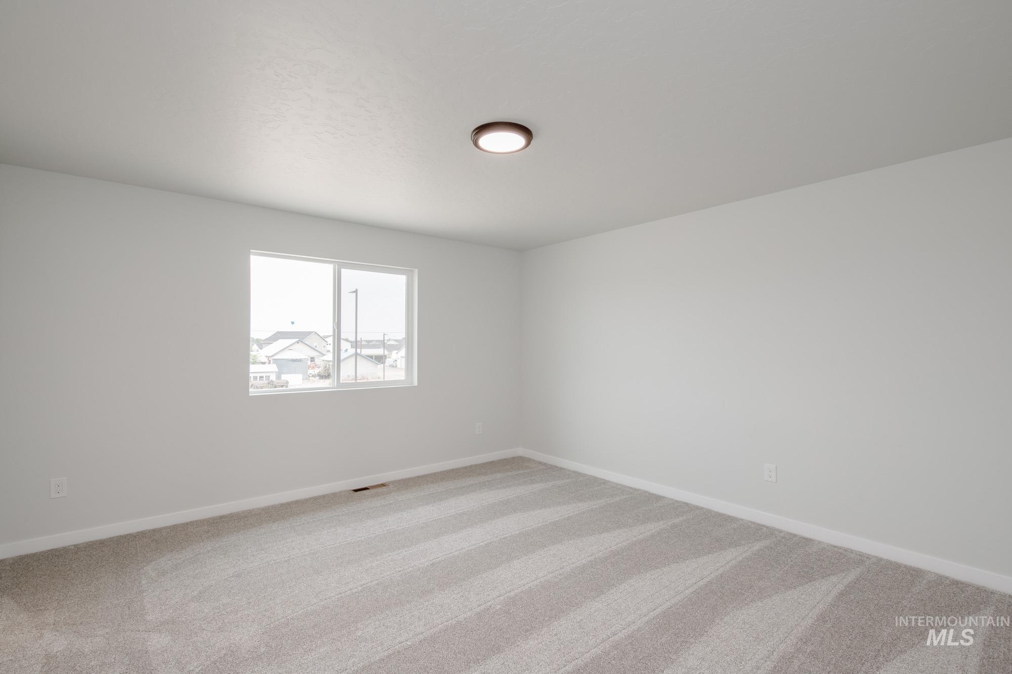 Empty room featuring light carpet