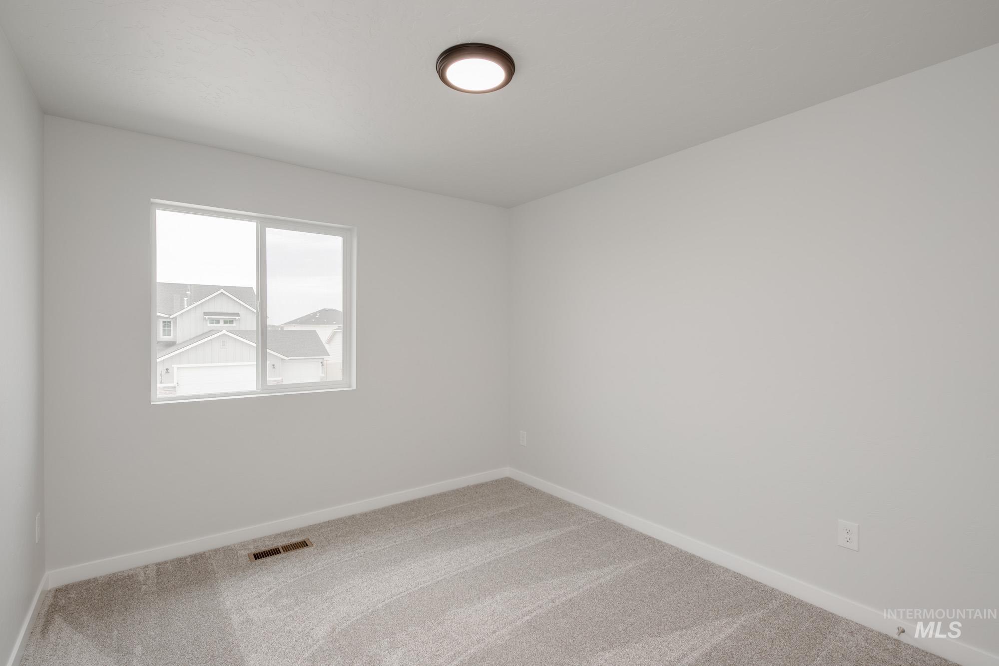 Empty room featuring baseboards and carpet flooring