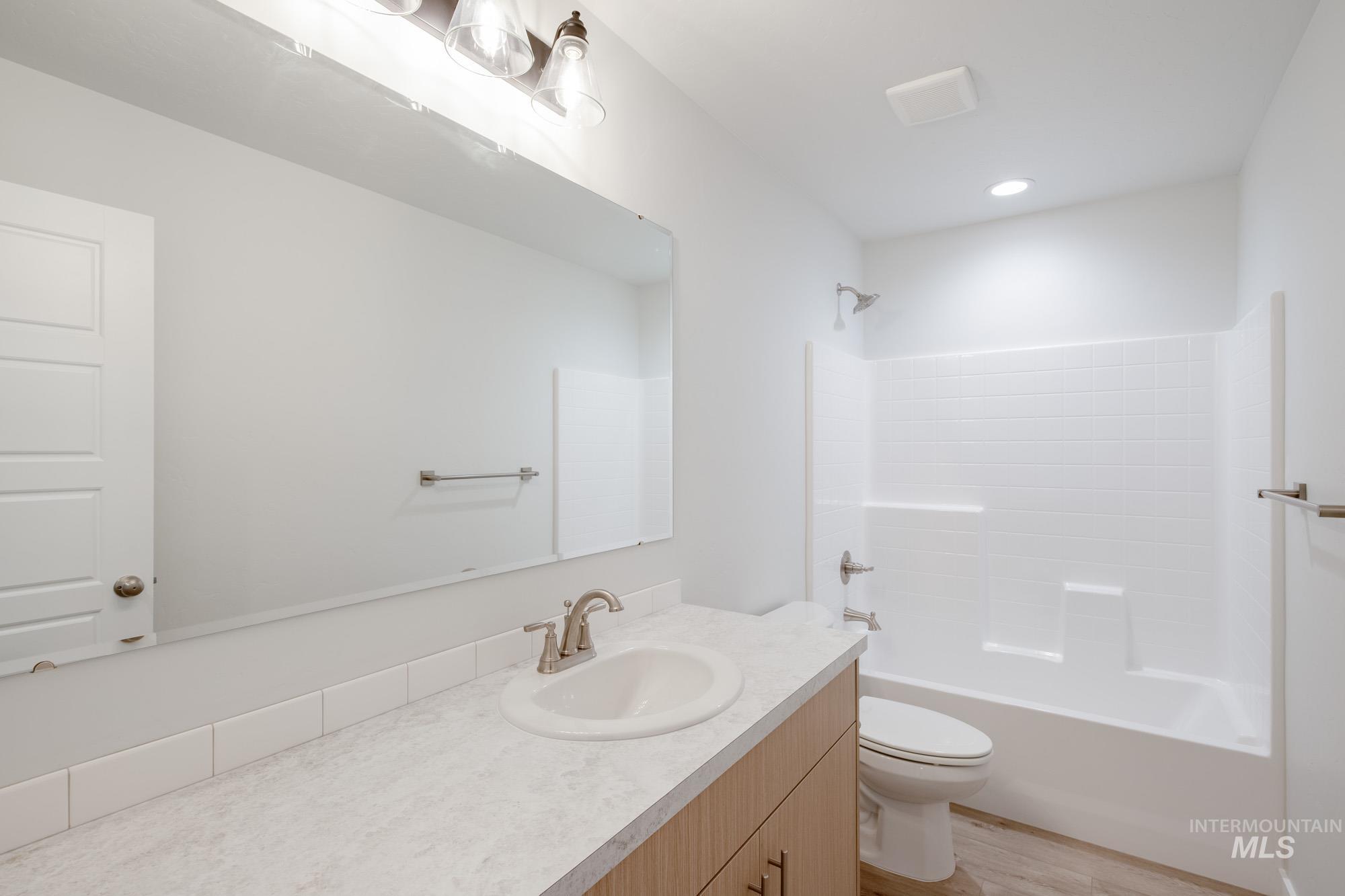 Full bathroom with shower / washtub combination, vanity, light wood-type flooring, and recessed lighting