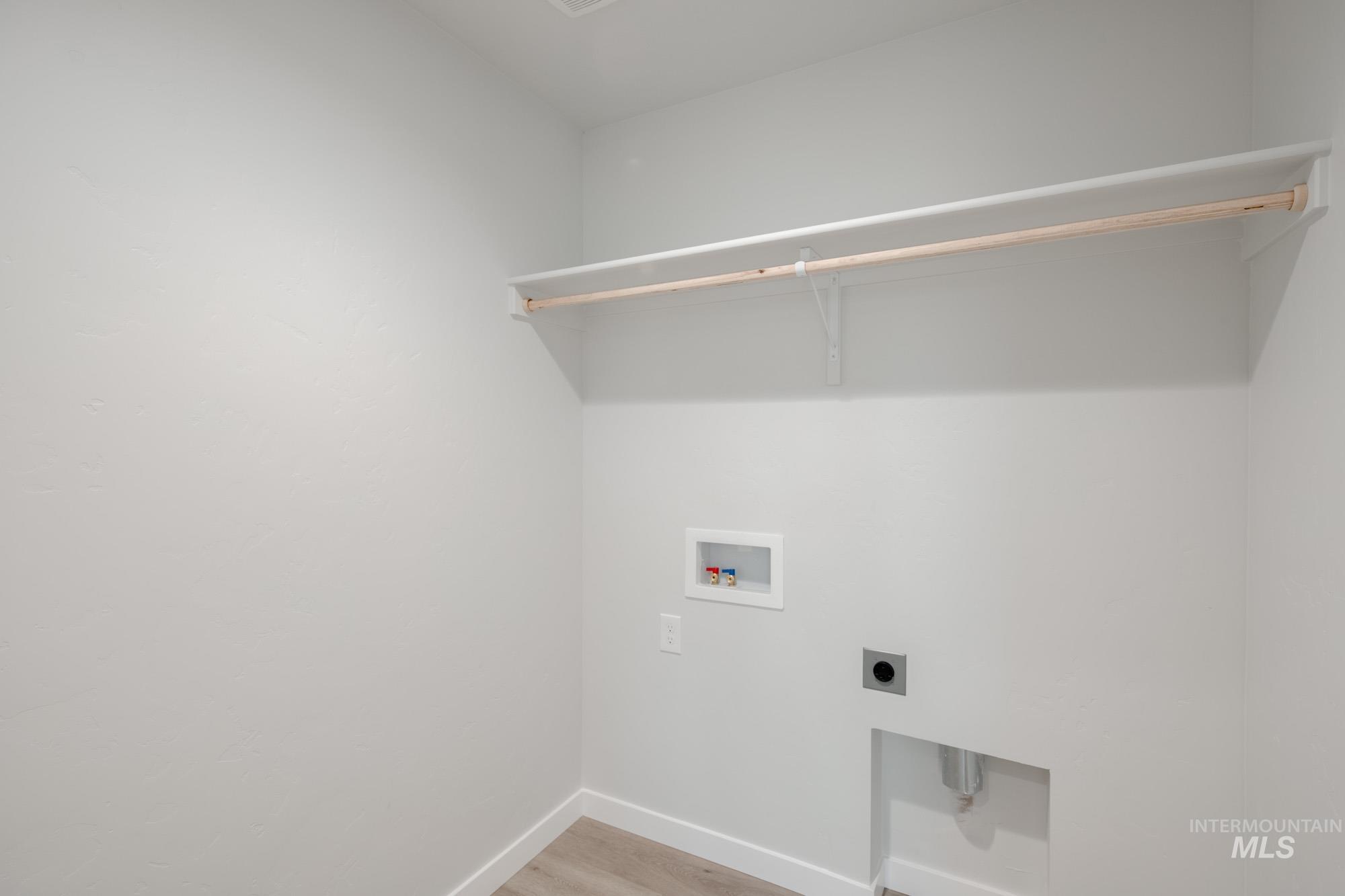 Laundry room with light wood-style flooring, washer hookup, and electric dryer hookup
