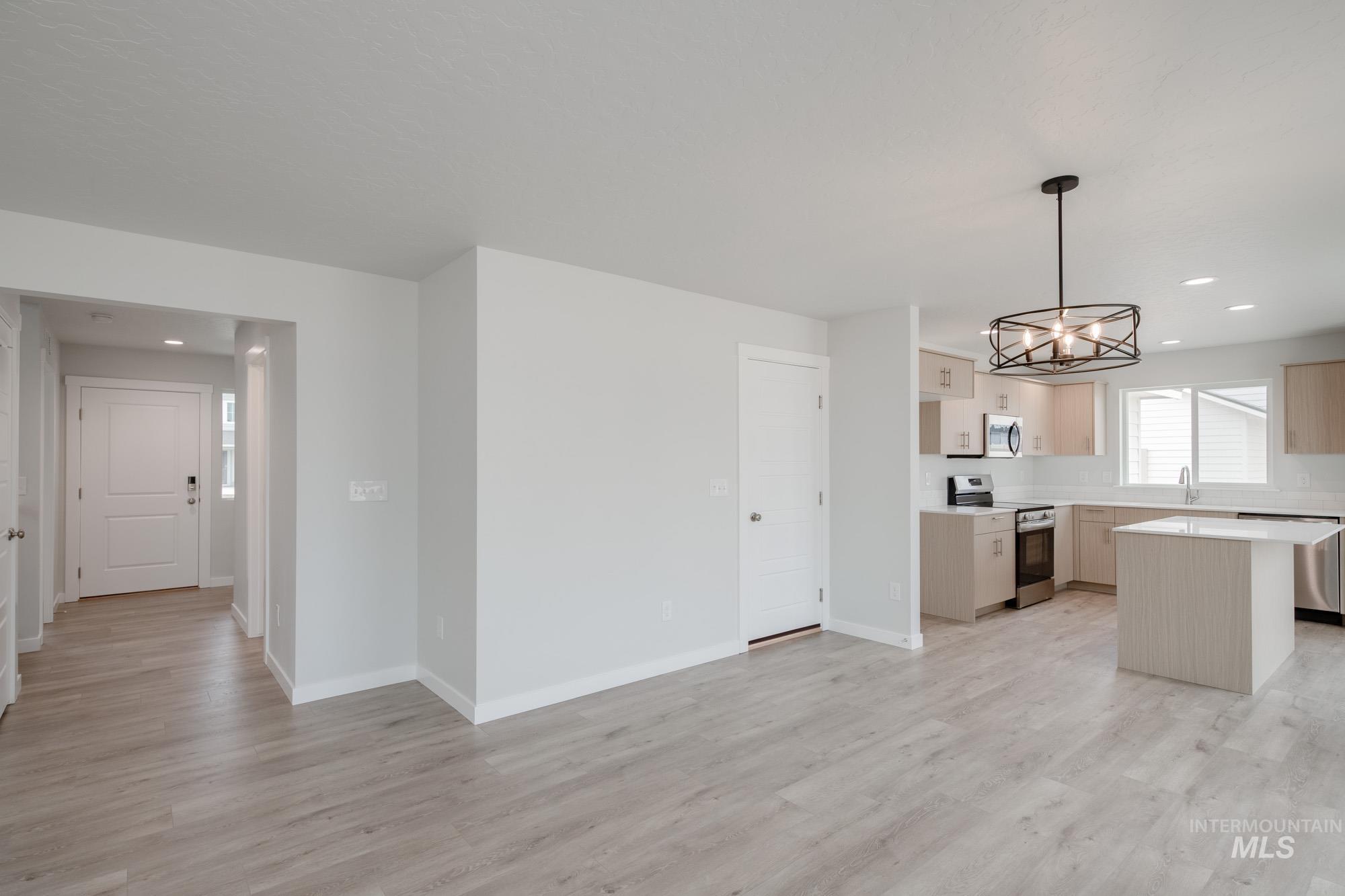 Kitchen featuring stainless steel appliances, a chandelier, decorative light fixtures, recessed lighting, and light wood-style flooring