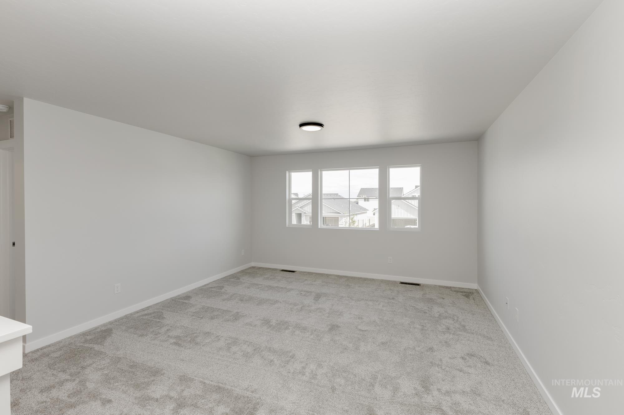 Spare room with light colored carpet and baseboards