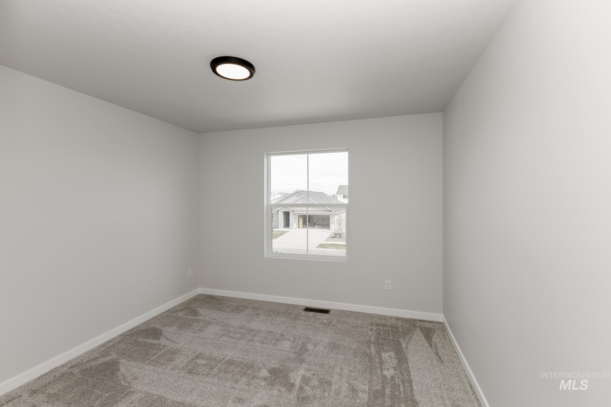 Carpeted spare room with baseboards