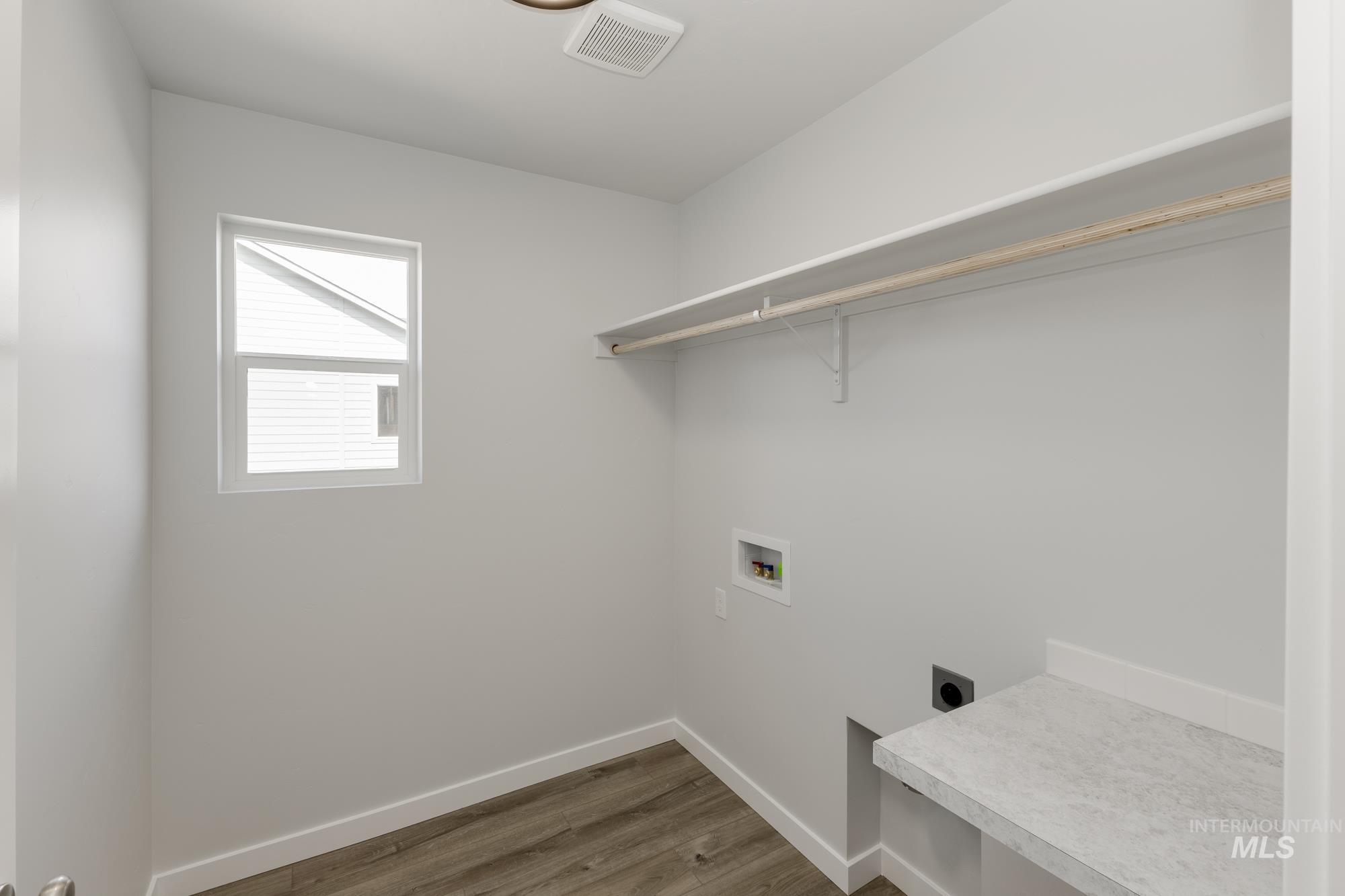Laundry area with electric dryer hookup, dark wood-type flooring, and hookup for a washing machine