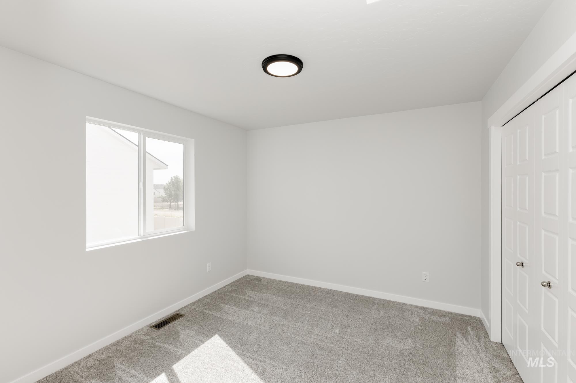 Unfurnished bedroom featuring light carpet and a closet