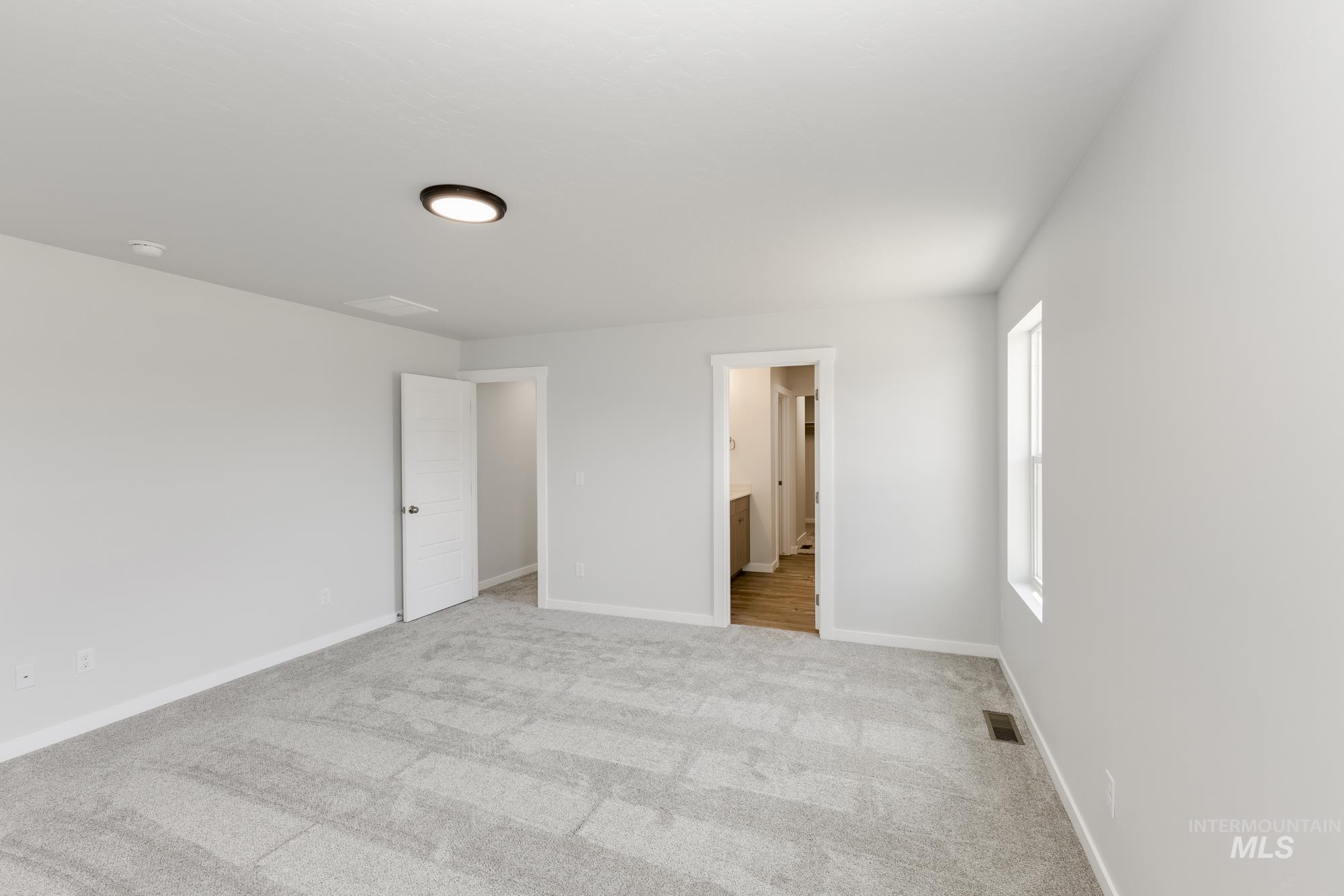 Unfurnished bedroom featuring carpet floors and connected bathroom