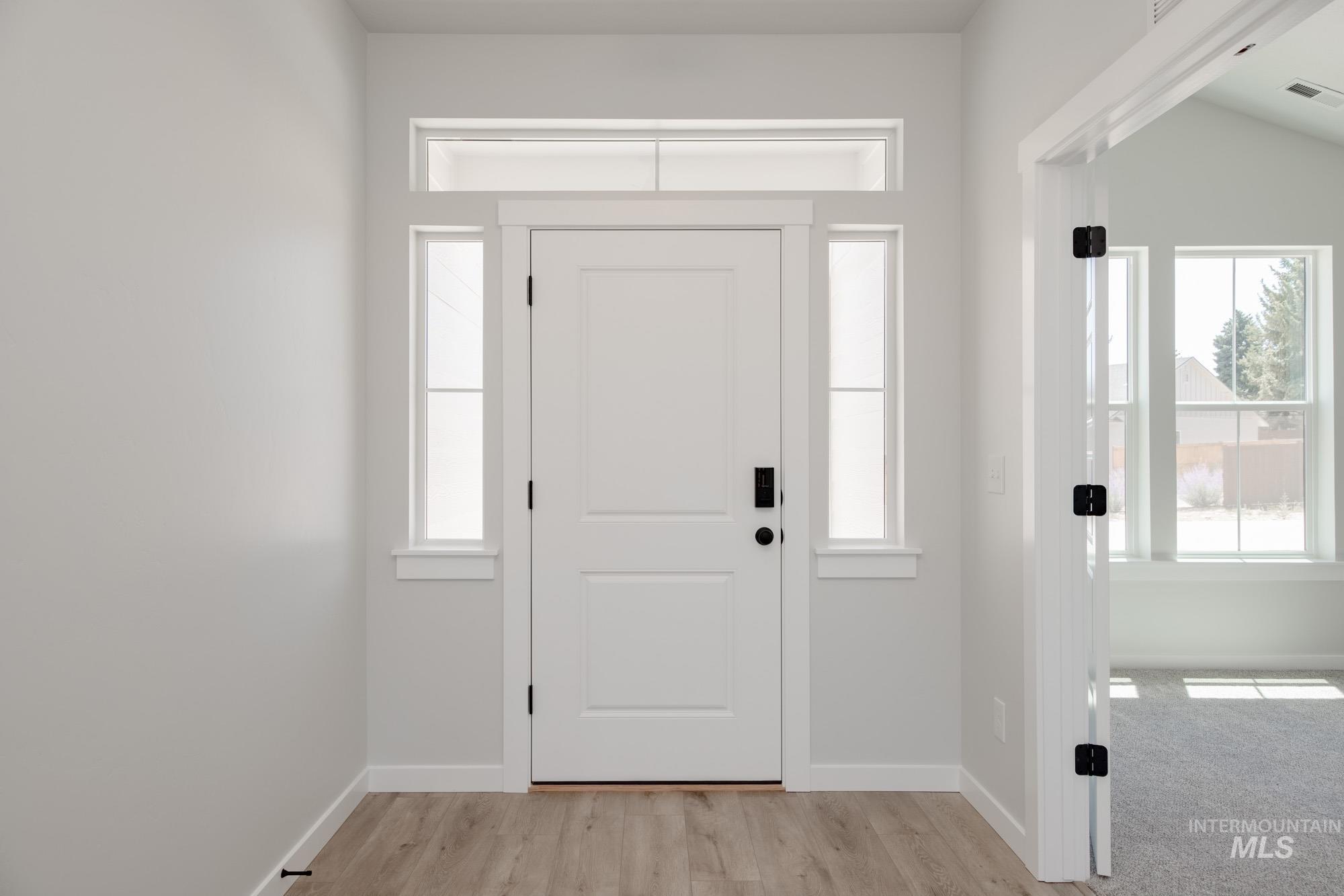 Foyer featuring baseboards and light wood-style flooring