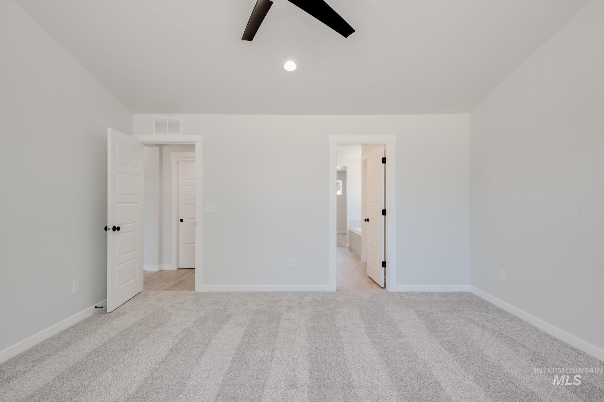 Unfurnished bedroom featuring light colored carpet, ceiling fan, recessed lighting, and connected bathroom