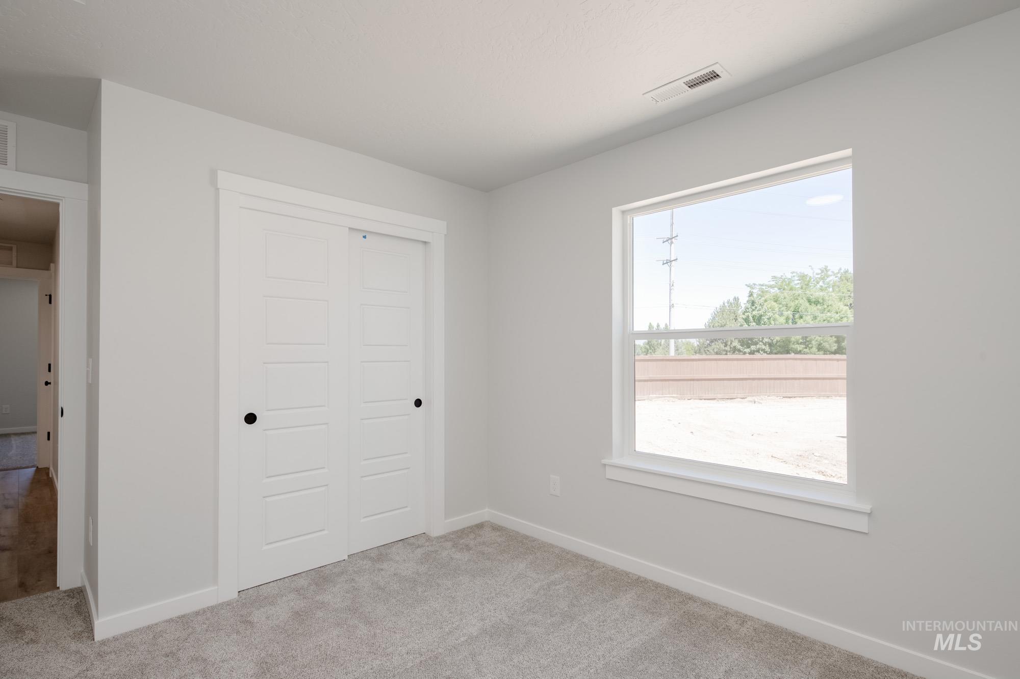 Unfurnished bedroom featuring a closet and light colored carpet