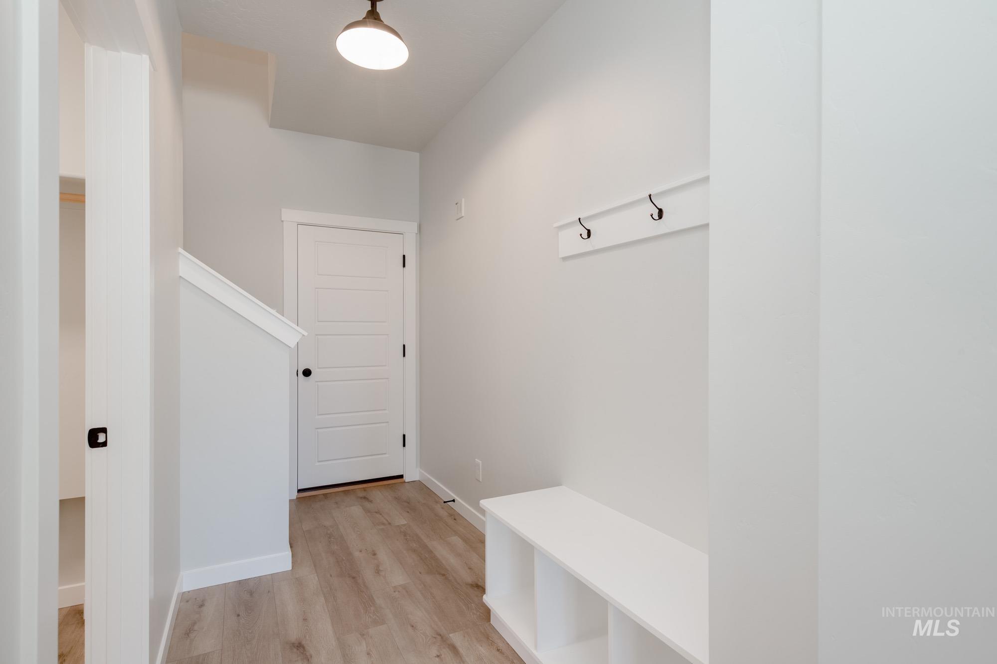 Mudroom with light wood-style floors and baseboards