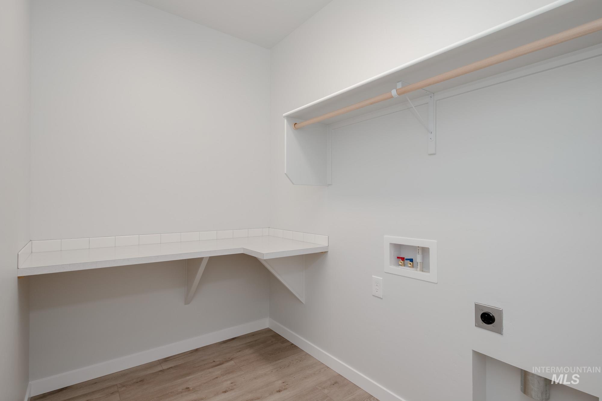Laundry room featuring light wood finished floors, hookup for a washing machine, and electric dryer hookup