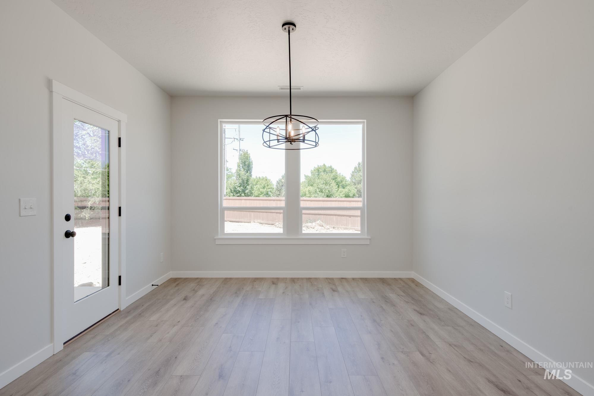 Unfurnished dining area featuring light wood-style flooring and a chandelier