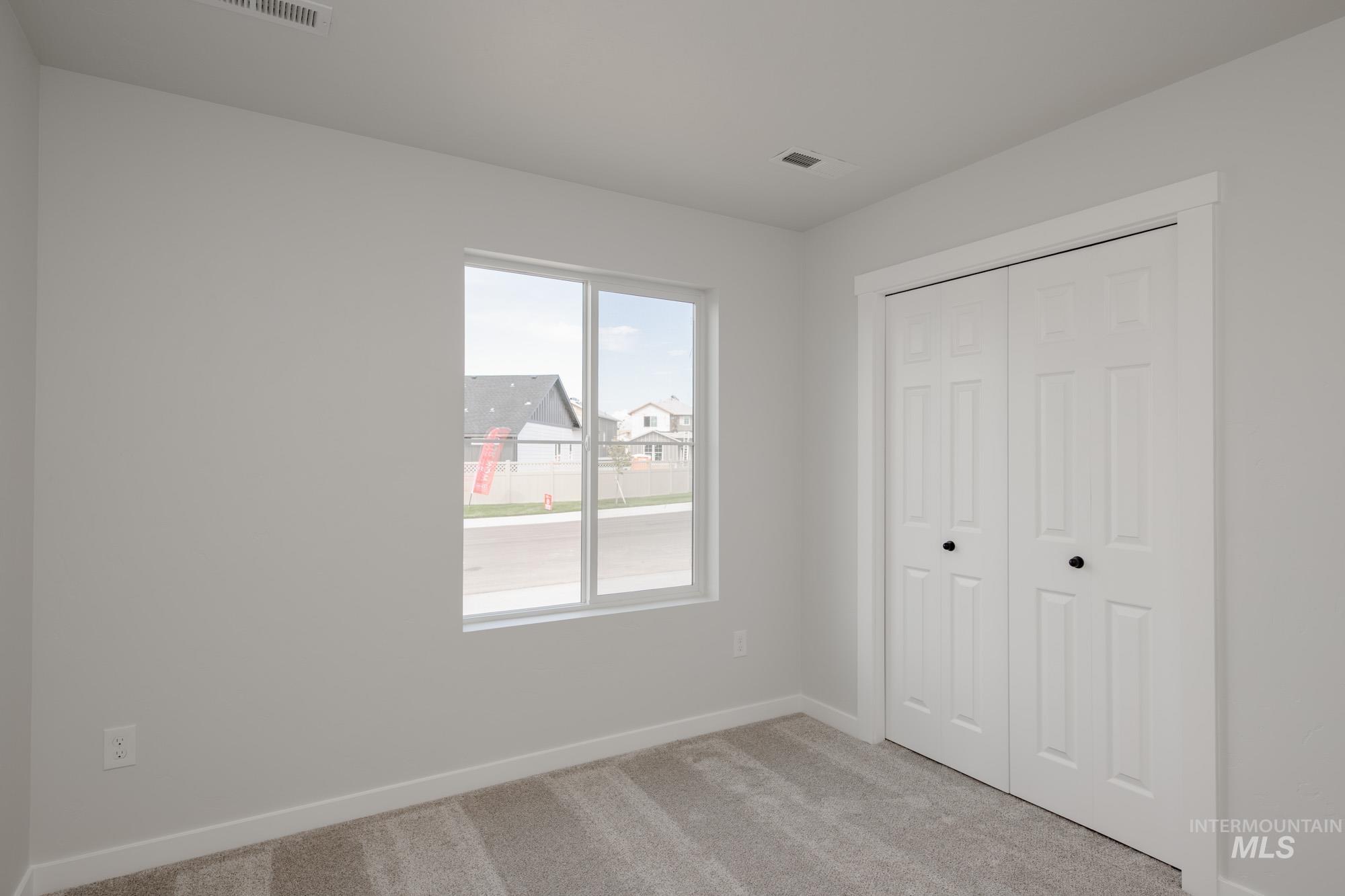 Unfurnished bedroom with light colored carpet and a closet
