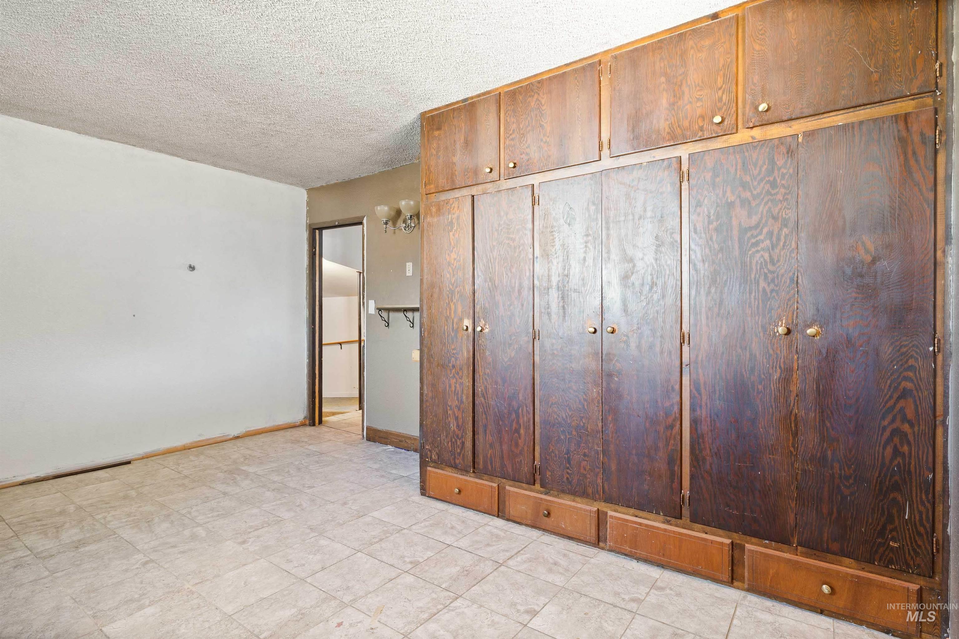 Unfurnished bedroom featuring a textured ceiling and a closet
