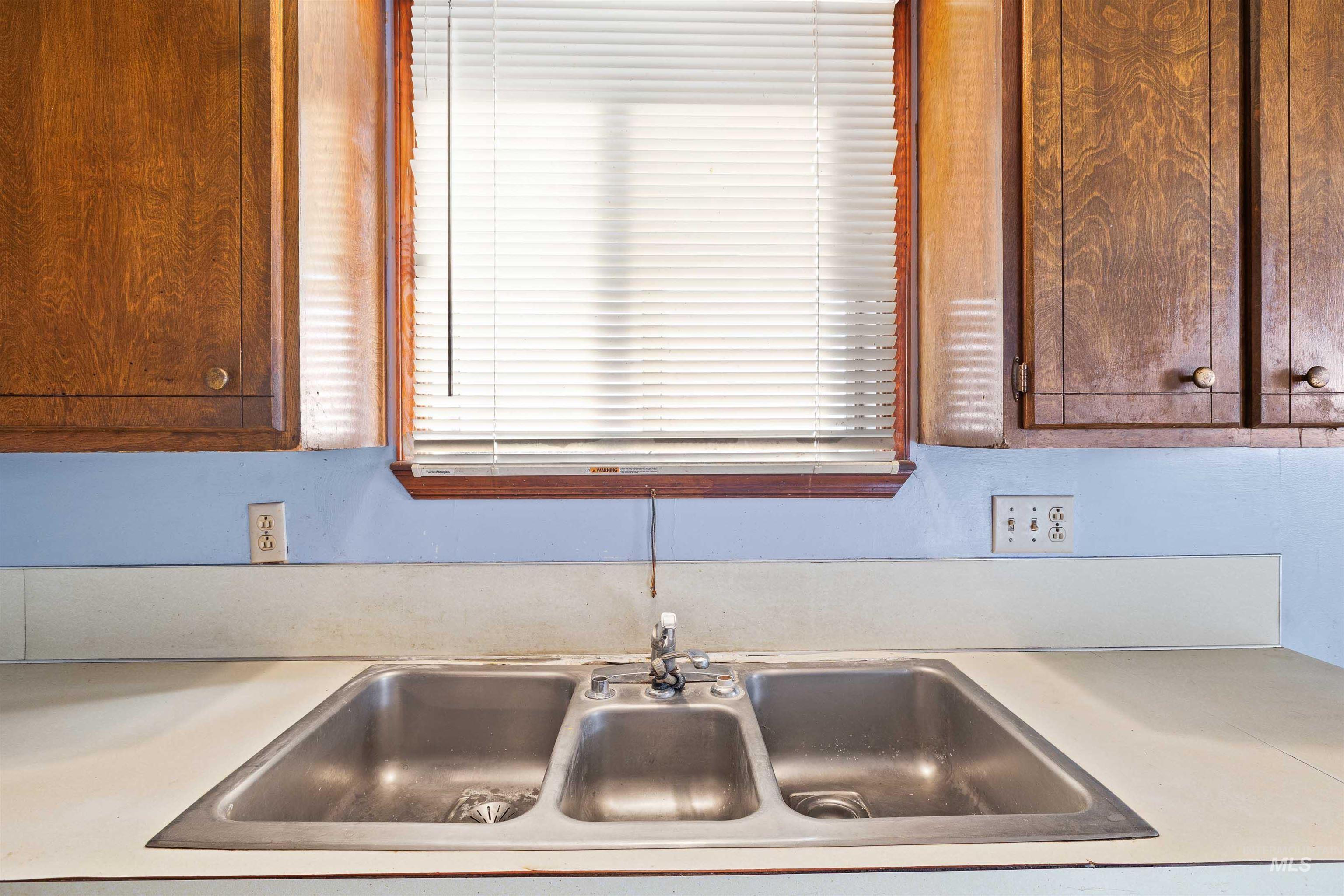 Kitchen view of a sink and light countertops