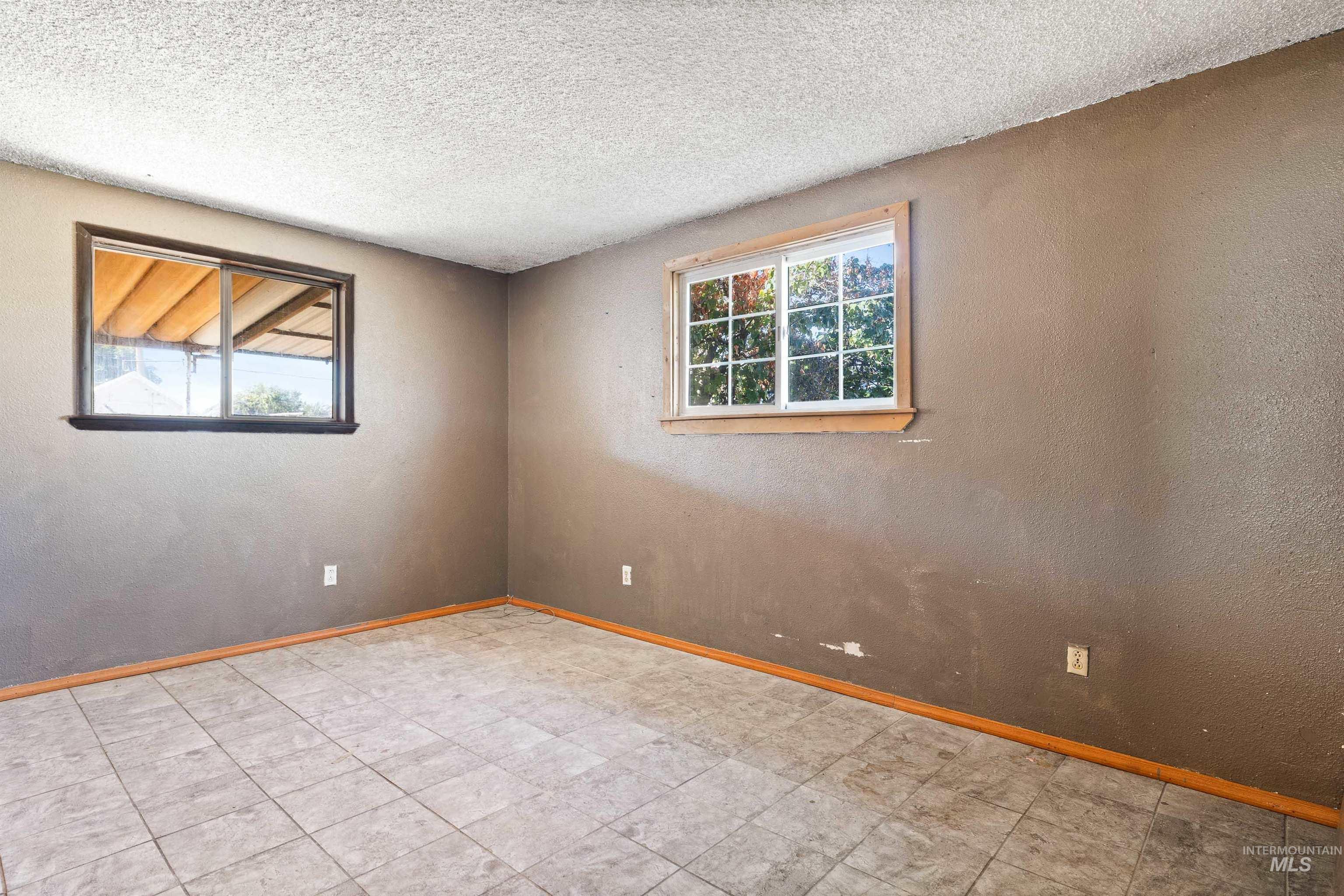 Unfurnished room featuring a textured wall and a textured ceiling