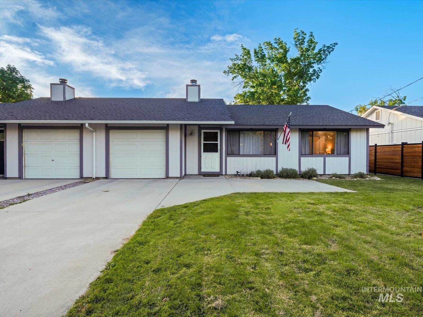 Ranch-style home with a shingled roof, a chimney, driveway, and a garage