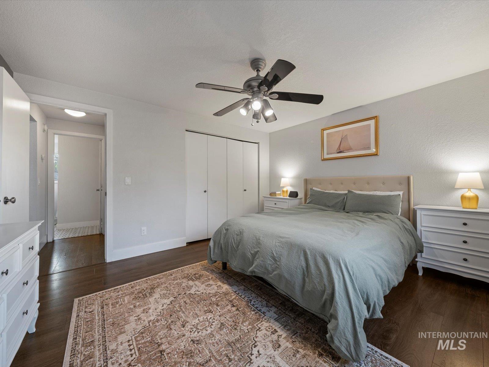 Bedroom featuring dark wood-style flooring, a closet, and ceiling fan