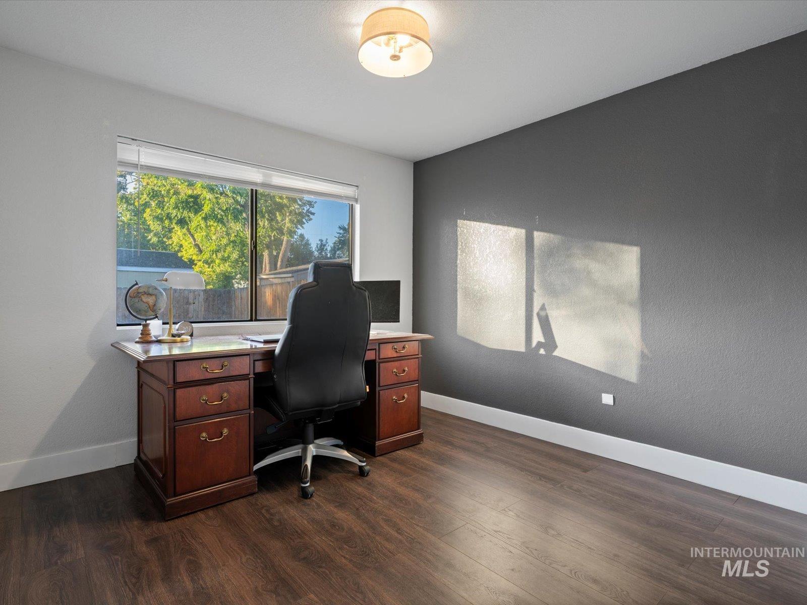 Office area featuring baseboards and dark wood-style flooring