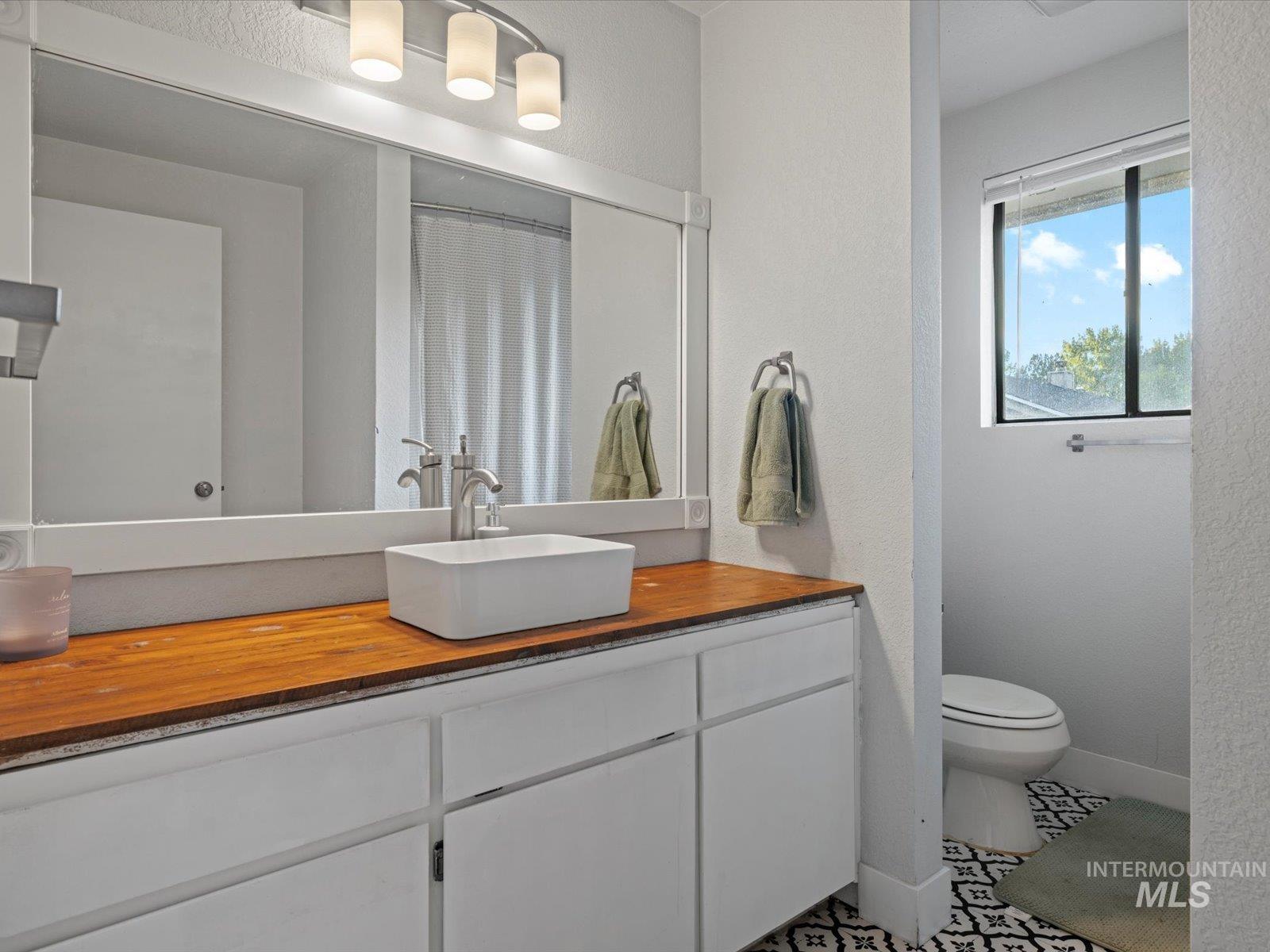 Full bath featuring vanity and a textured wall