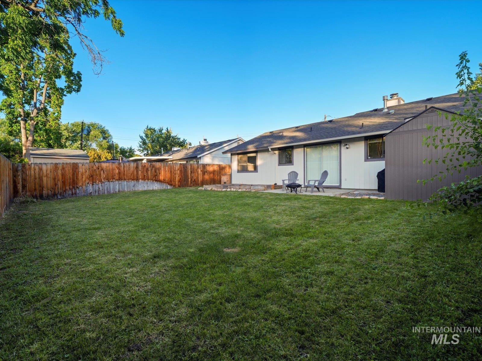 Fenced backyard featuring a patio area and a storage unit