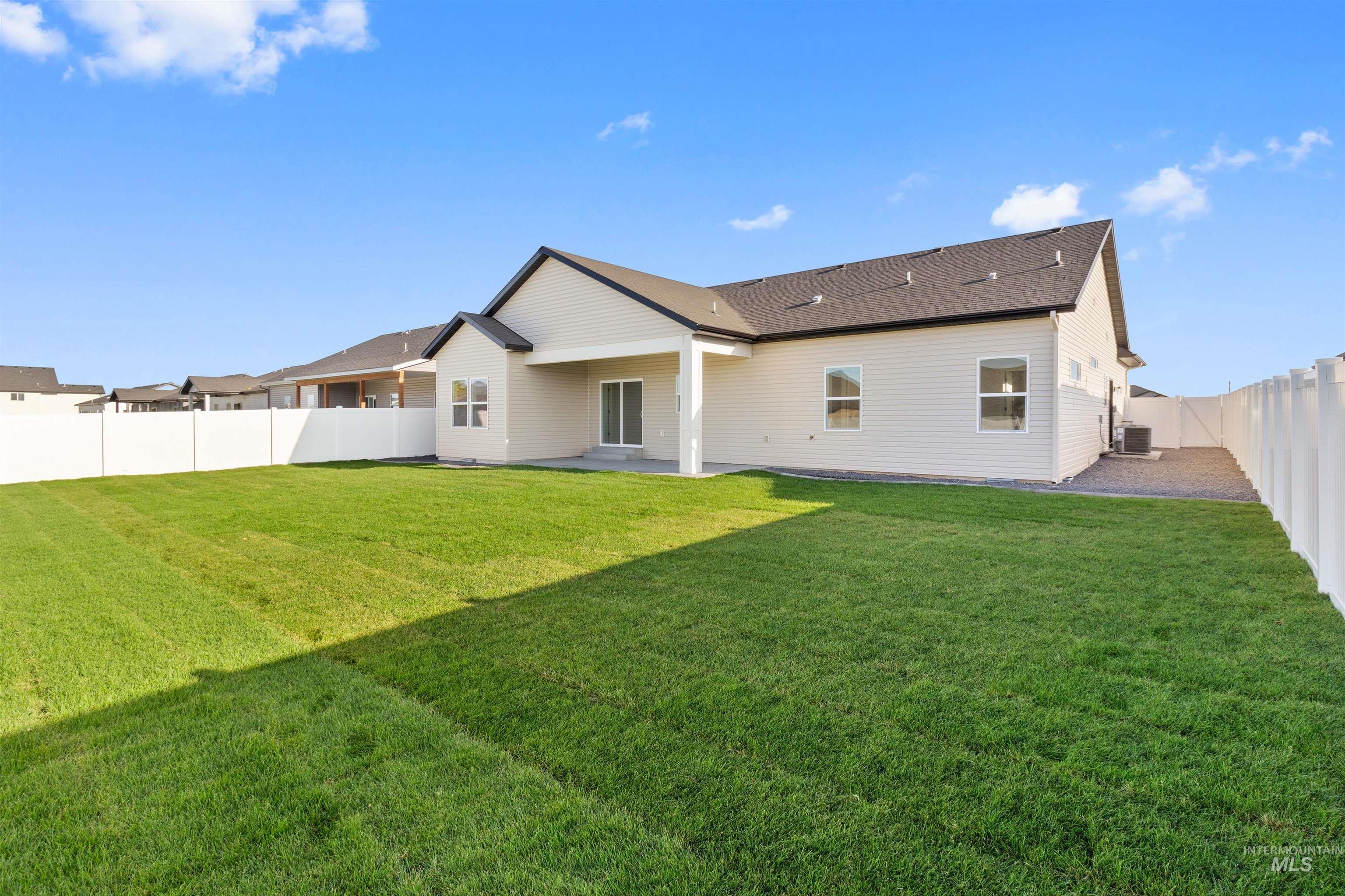 Back of house featuring a fenced backyard, a patio area, and roof with shingles