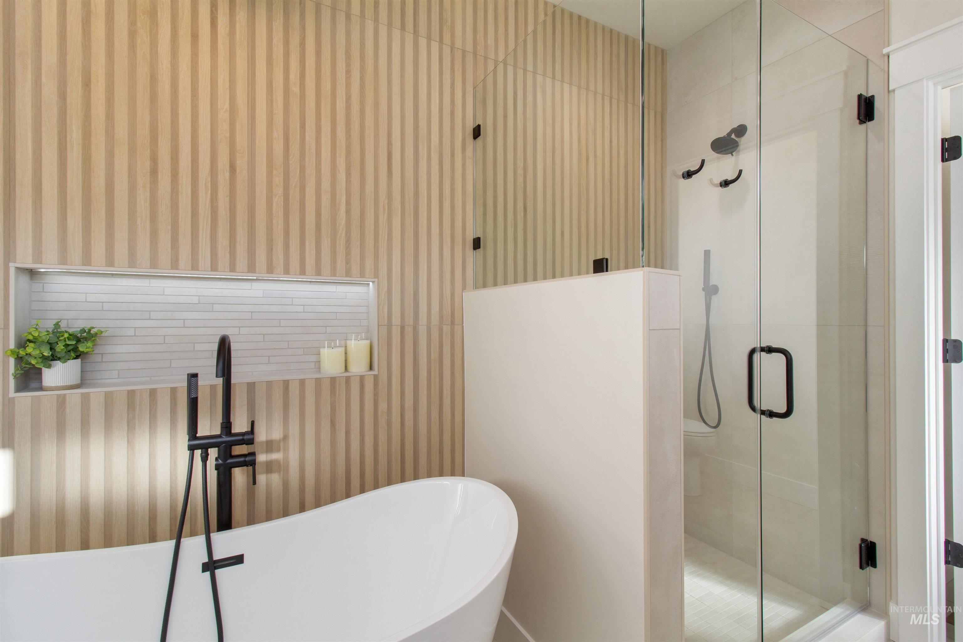 Bathroom featuring a freestanding bath, a stall shower, and wallpapered walls