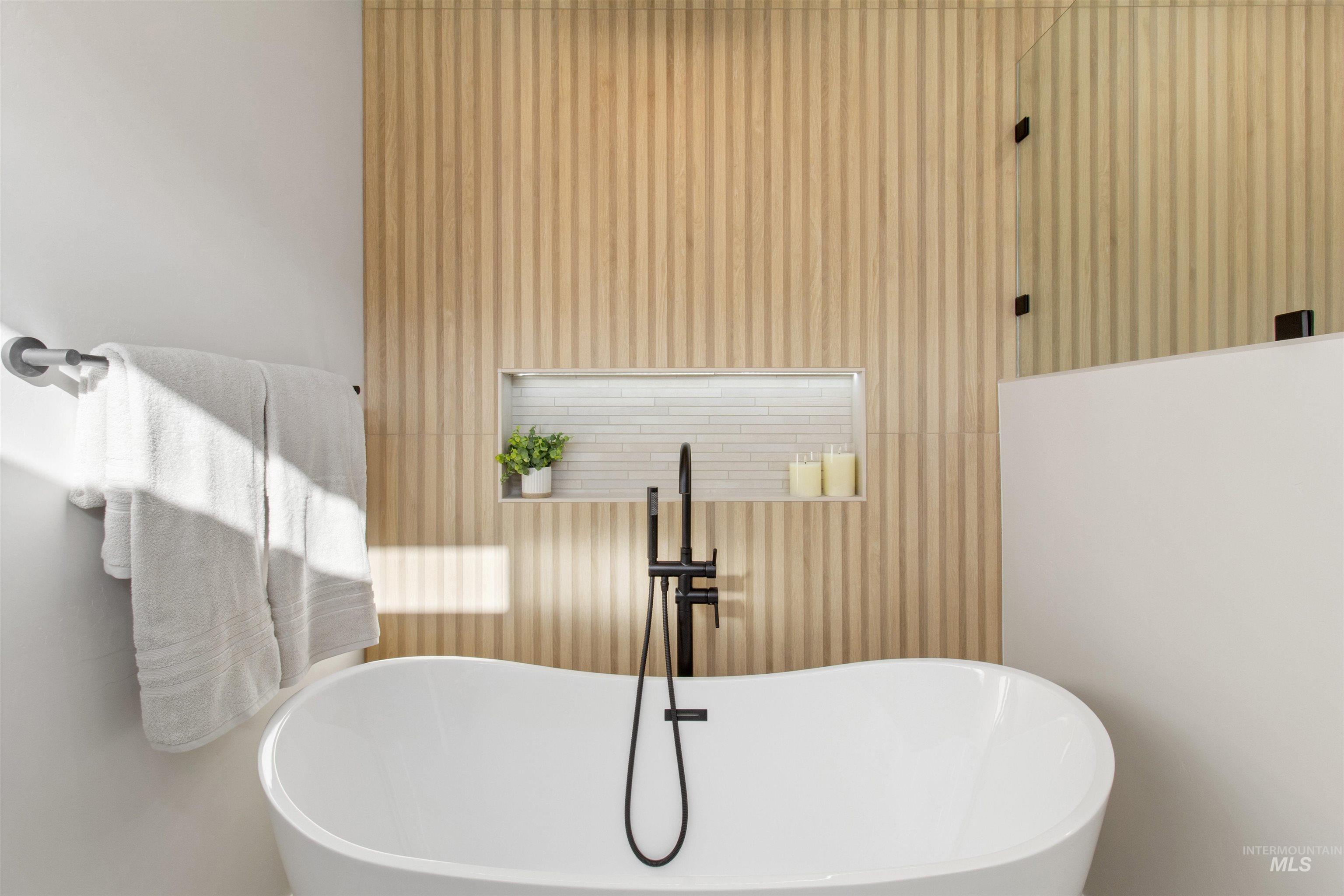 Bathroom featuring a soaking tub and wallpapered walls