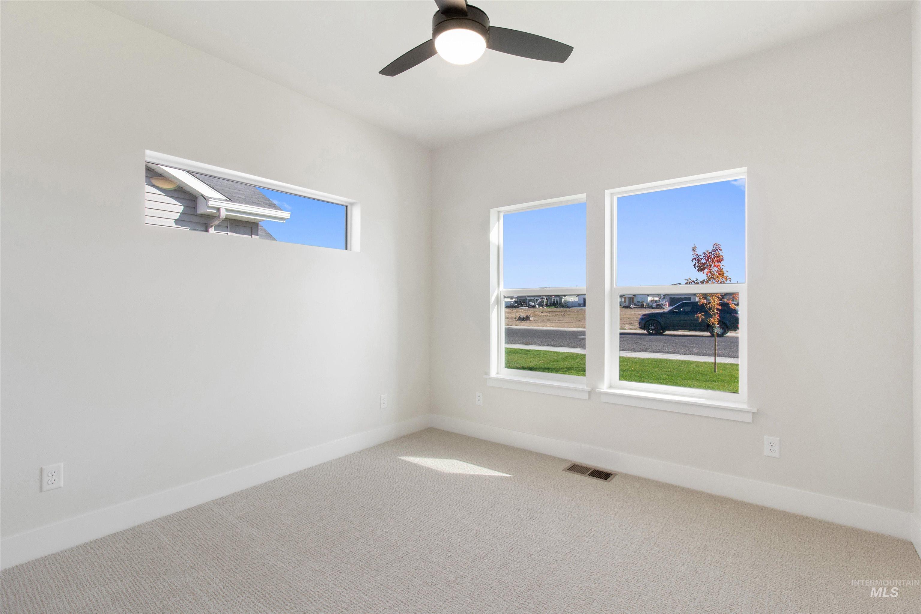 Empty room with carpet and ceiling fan