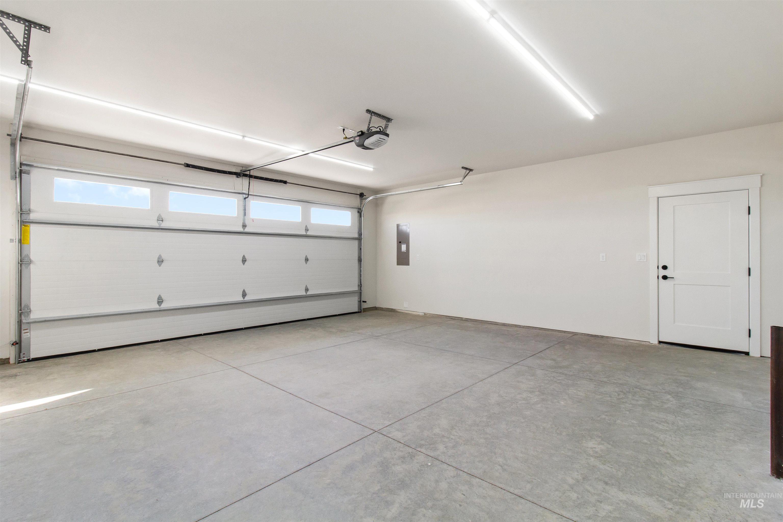 Garage featuring electric panel and a garage door opener
