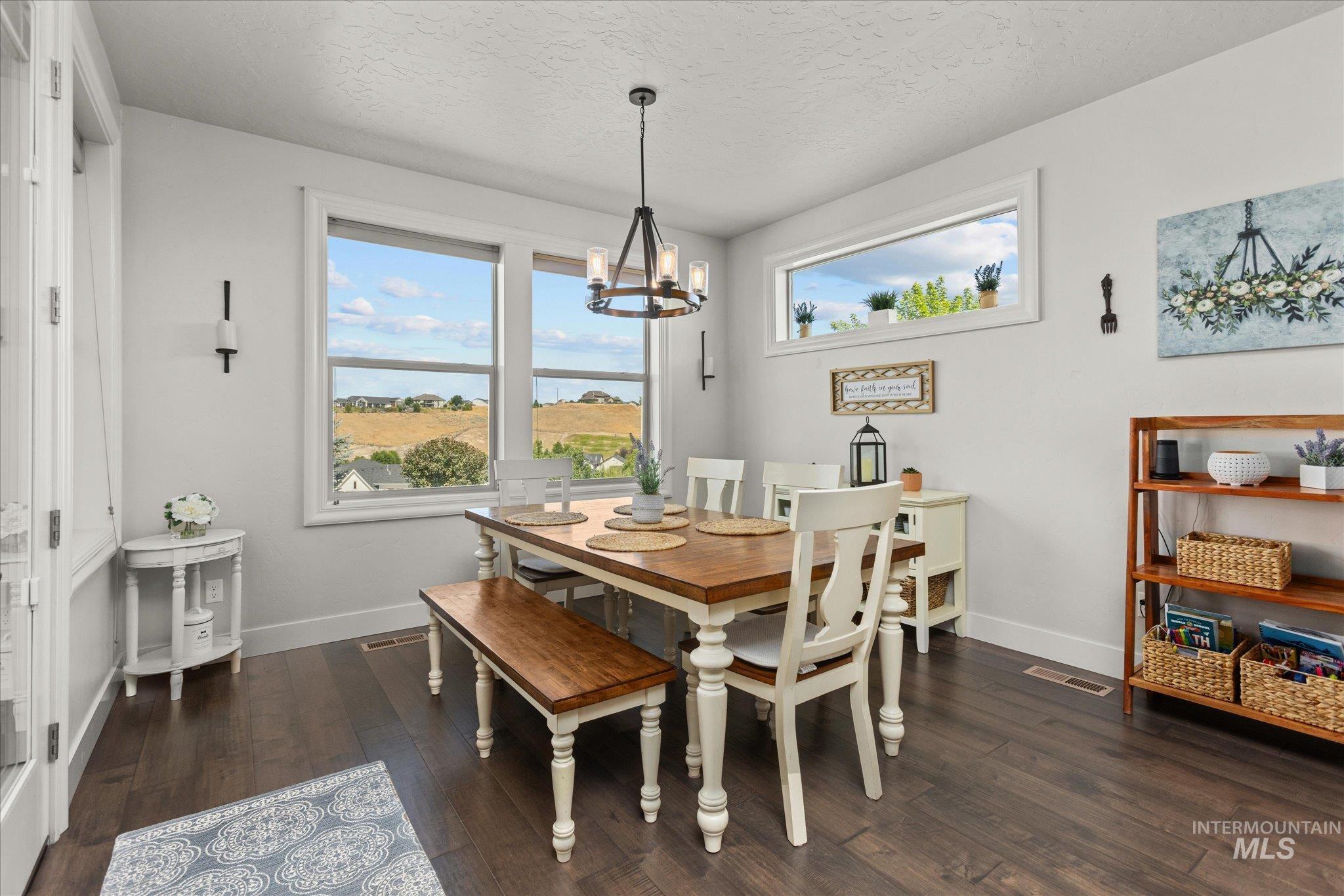 Dining room featuring a chandelier, hardwood / wood-style flooring, and a textured ceiling