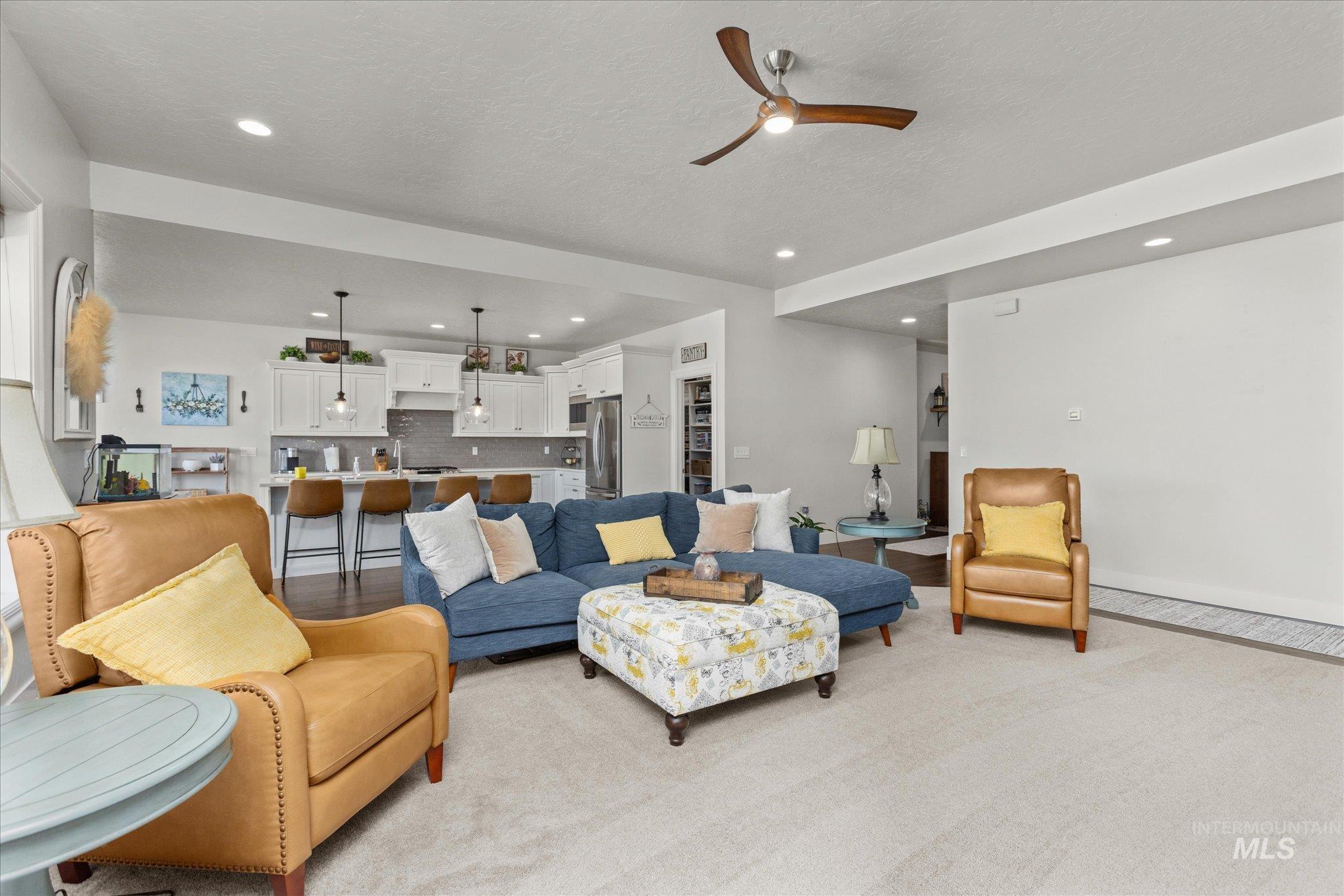 Living area featuring ceiling fan, recessed lighting, and a textured ceiling