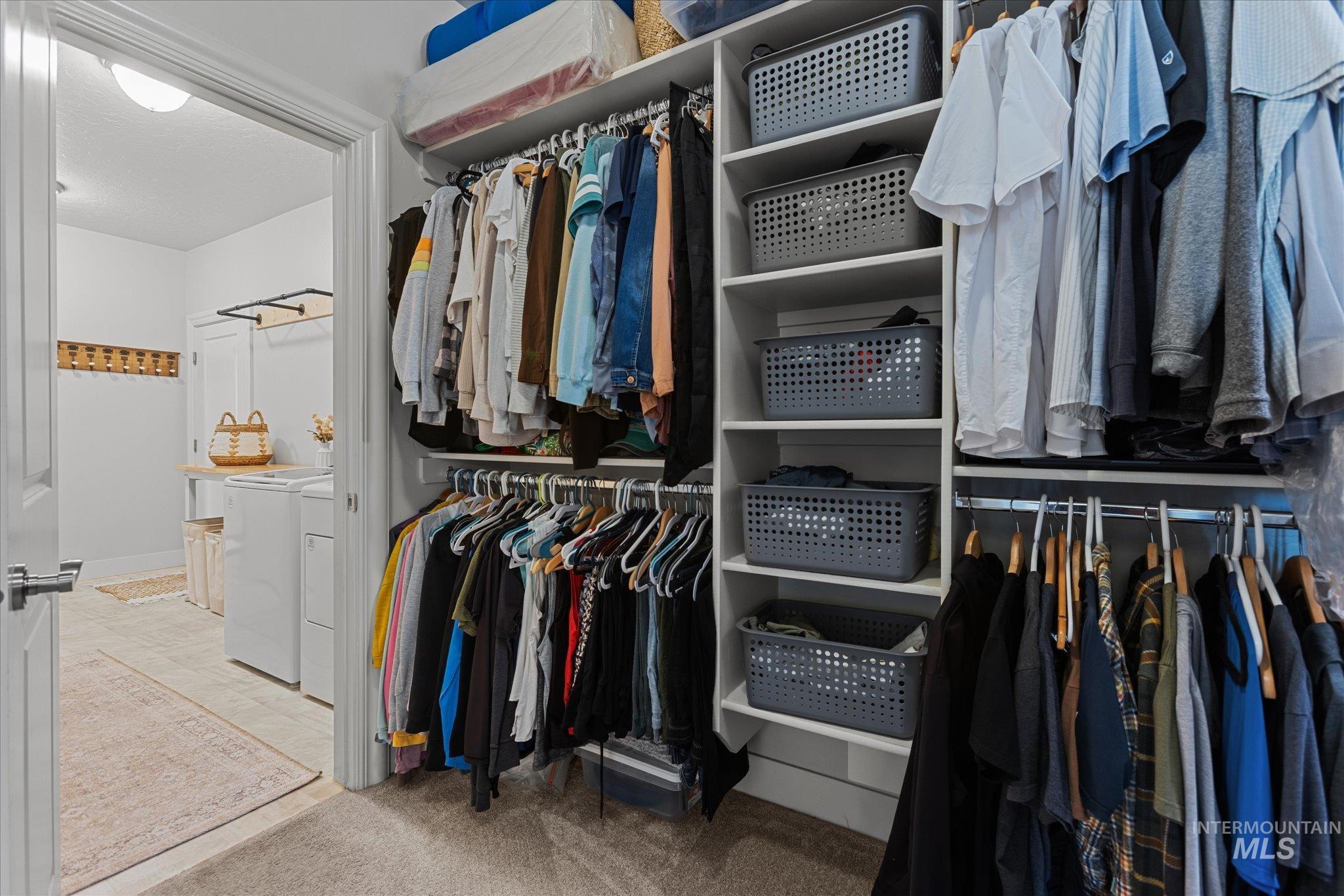 Walk in closet featuring independent washer and dryer and carpet