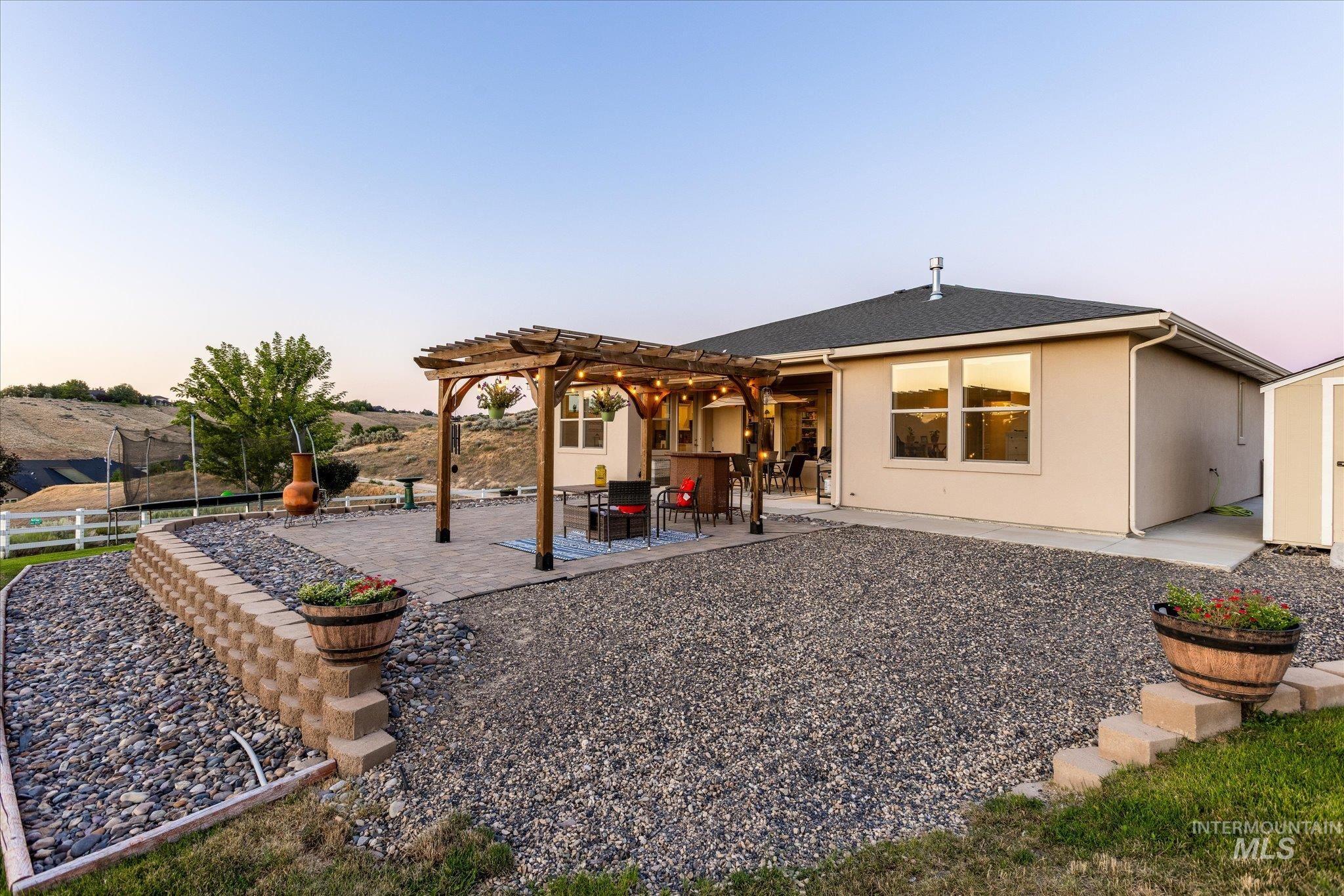 Rear view of property with a pergola, stucco siding, and a patio