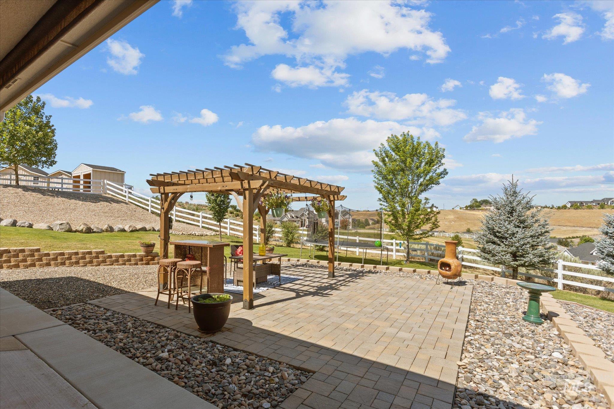 Fenced backyard with a pergola and a patio area
