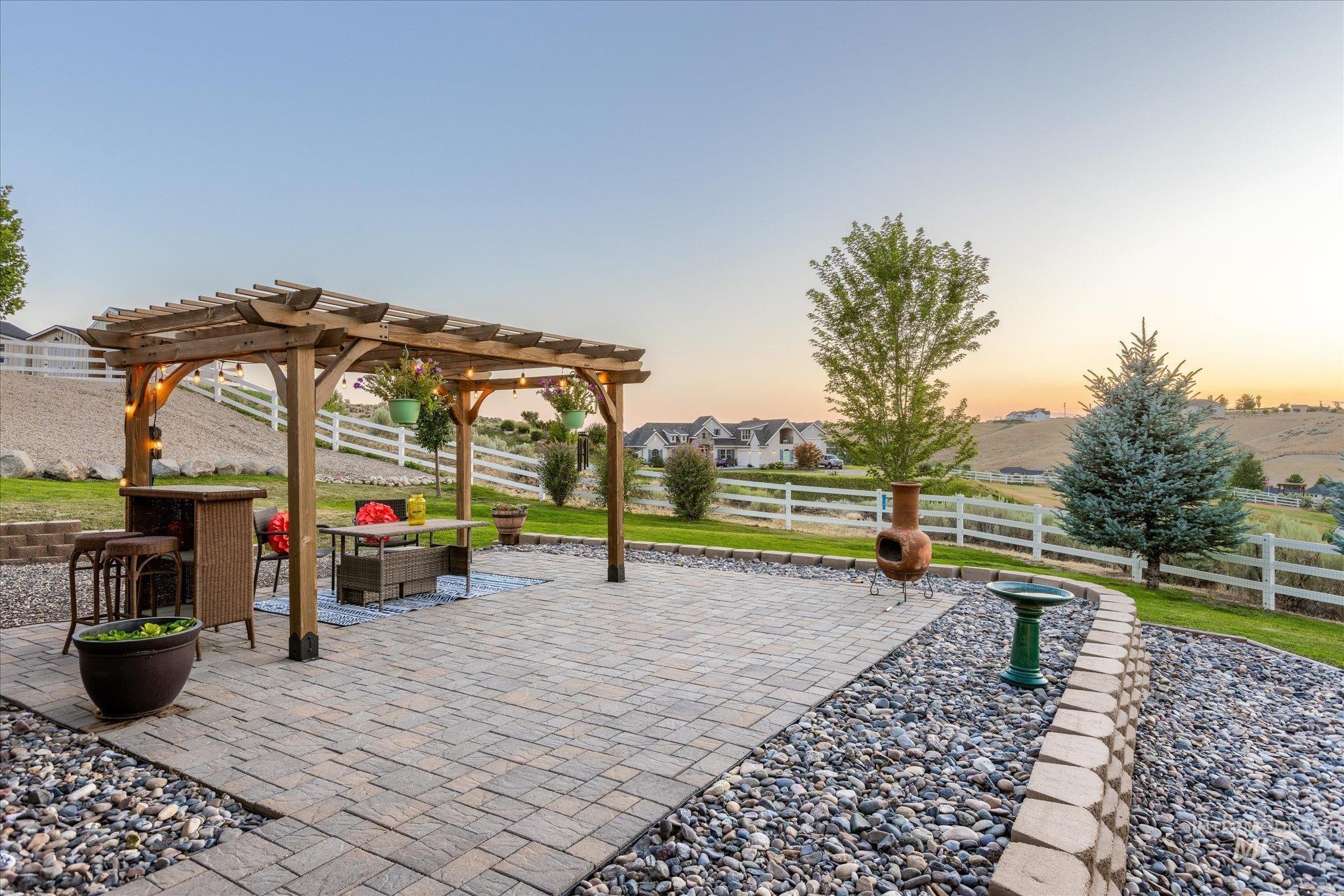 Patio terrace at dusk with a pergola, a patio area, a fenced backyard, and an outdoor hangout area