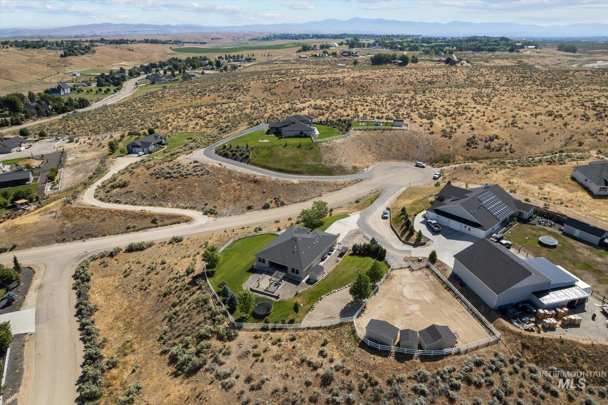 Aerial view of property and surrounding area featuring rural landscape and a mountainous background