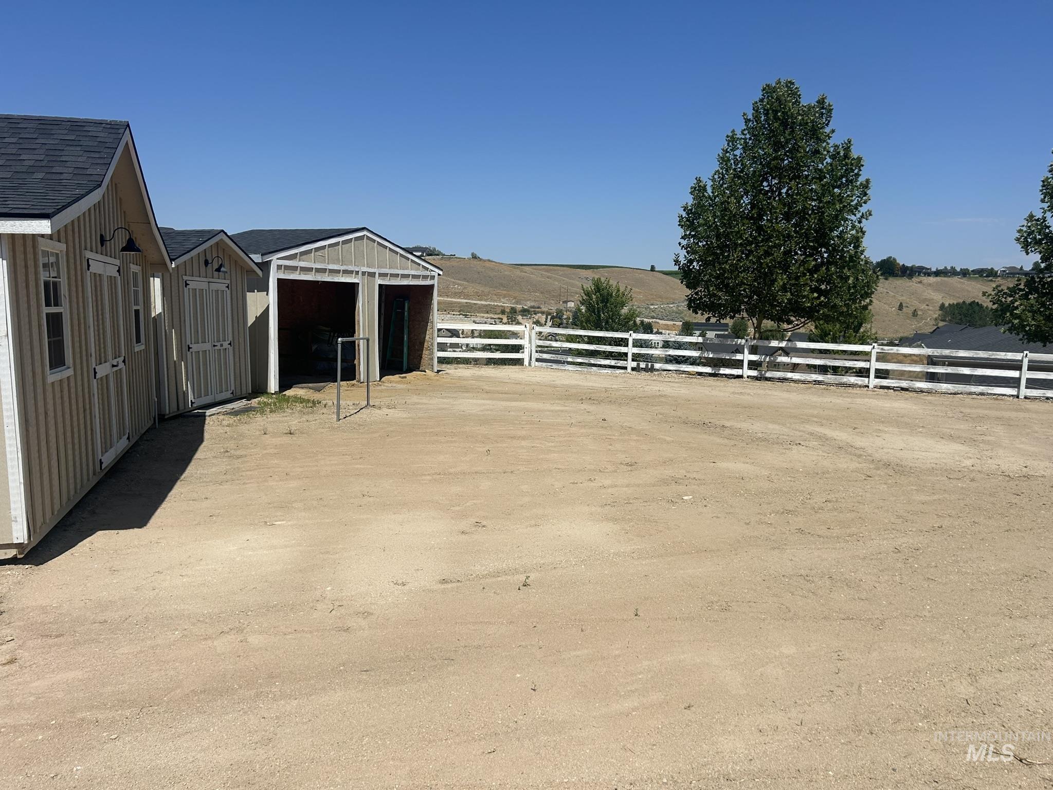 View of yard featuring an outbuilding, a detached garage, and a view of countryside