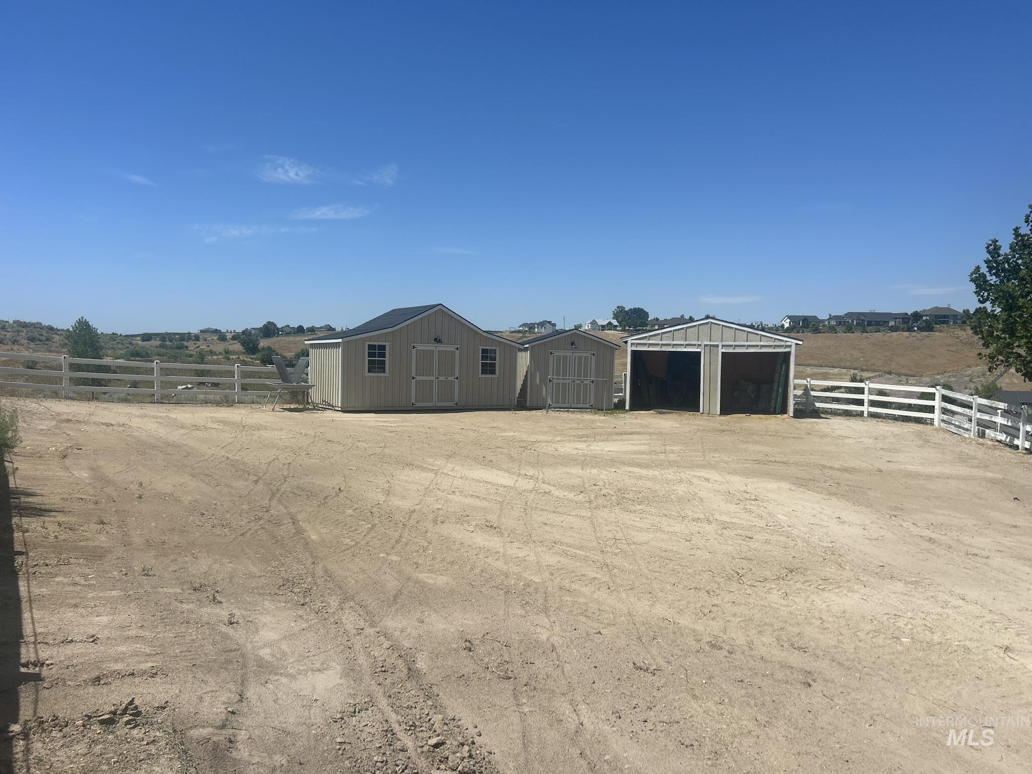 View of yard with a detached garage, an outdoor structure, and a view of countryside