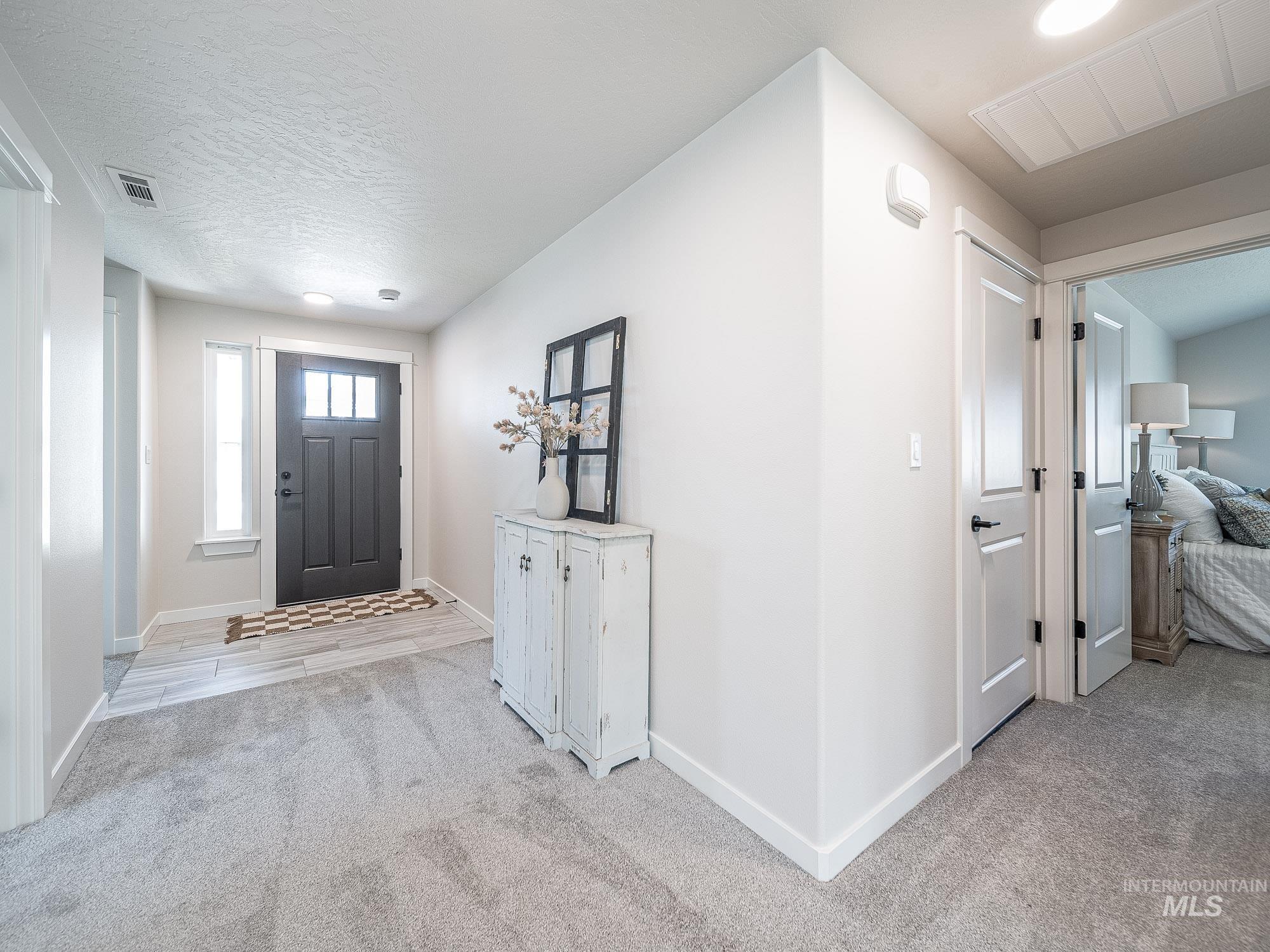 Entryway with light carpet and baseboards