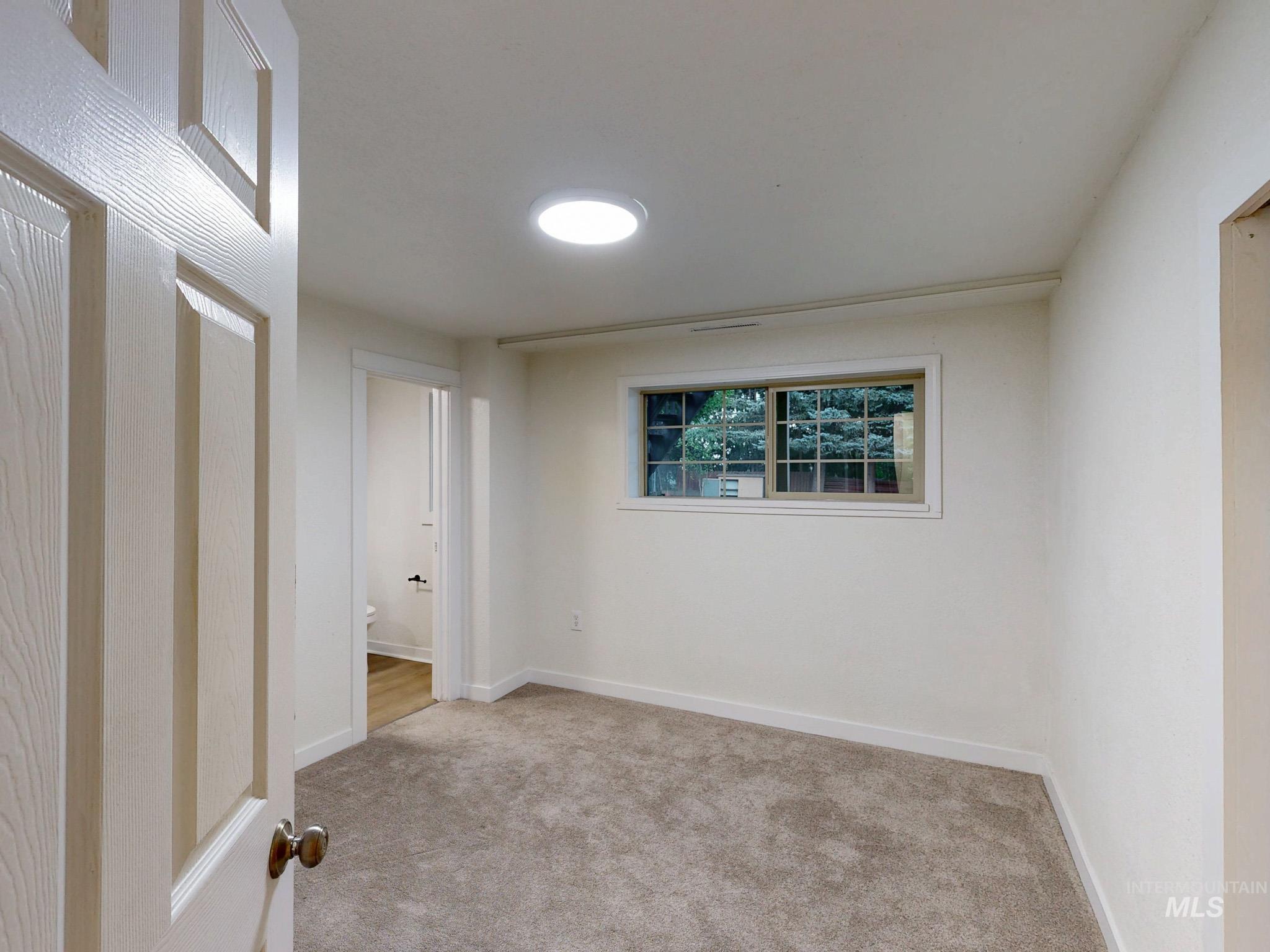 Carpeted empty room featuring baseboards