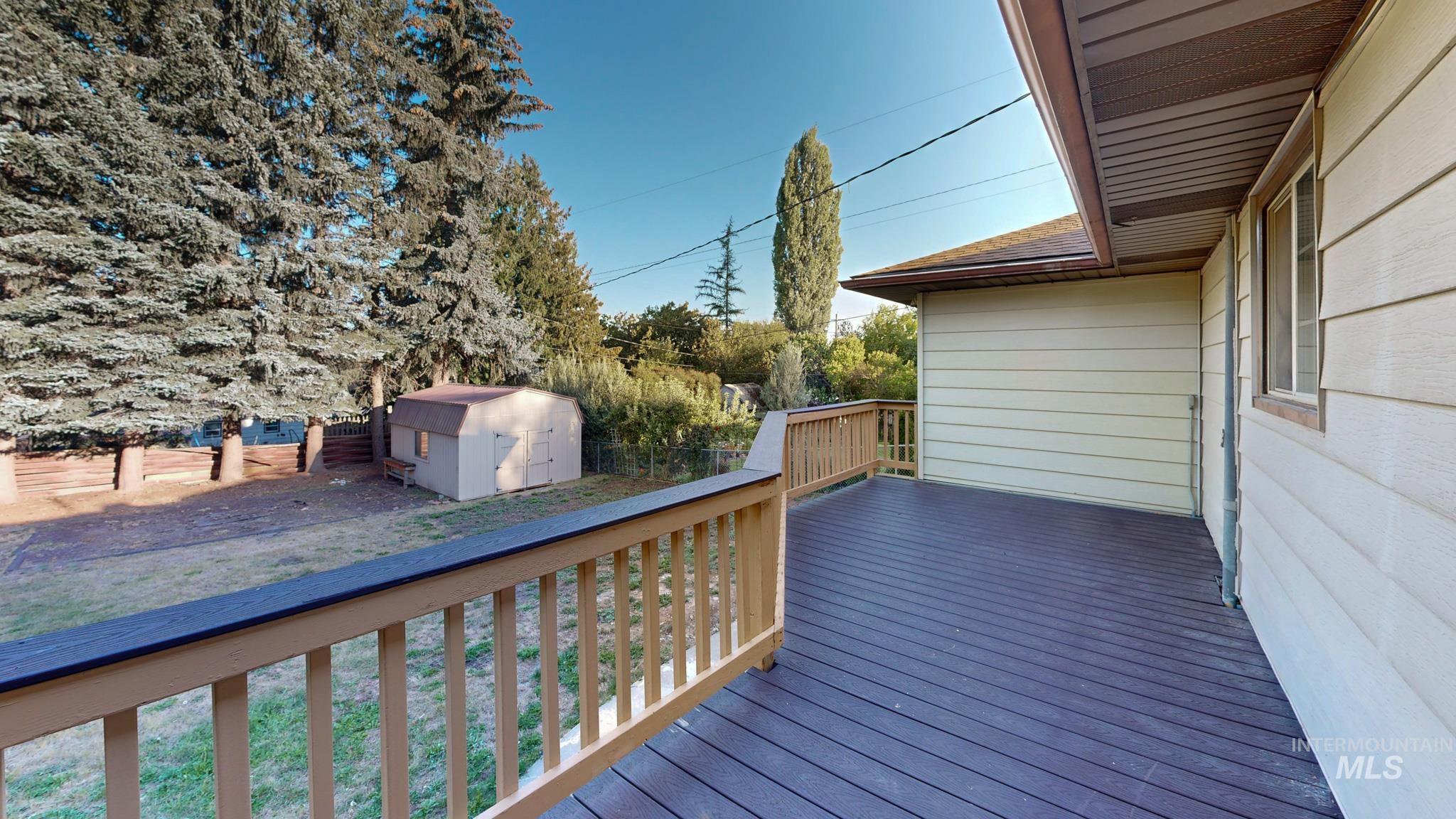 Wooden deck with a storage unit and a fenced backyard