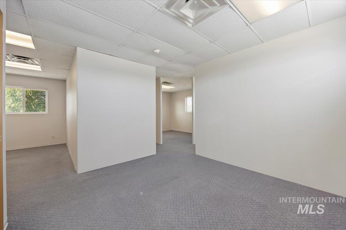 Empty room with a drop ceiling and carpet floors