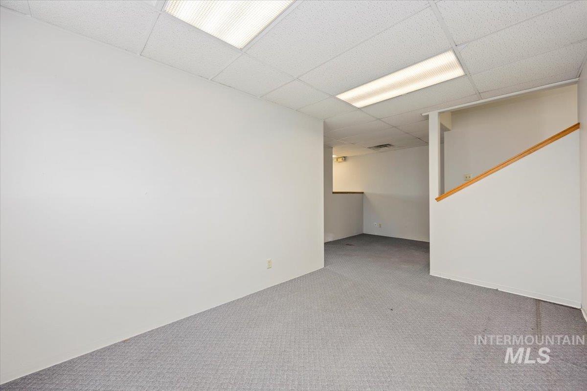 Finished basement with a drop ceiling and carpet floors
