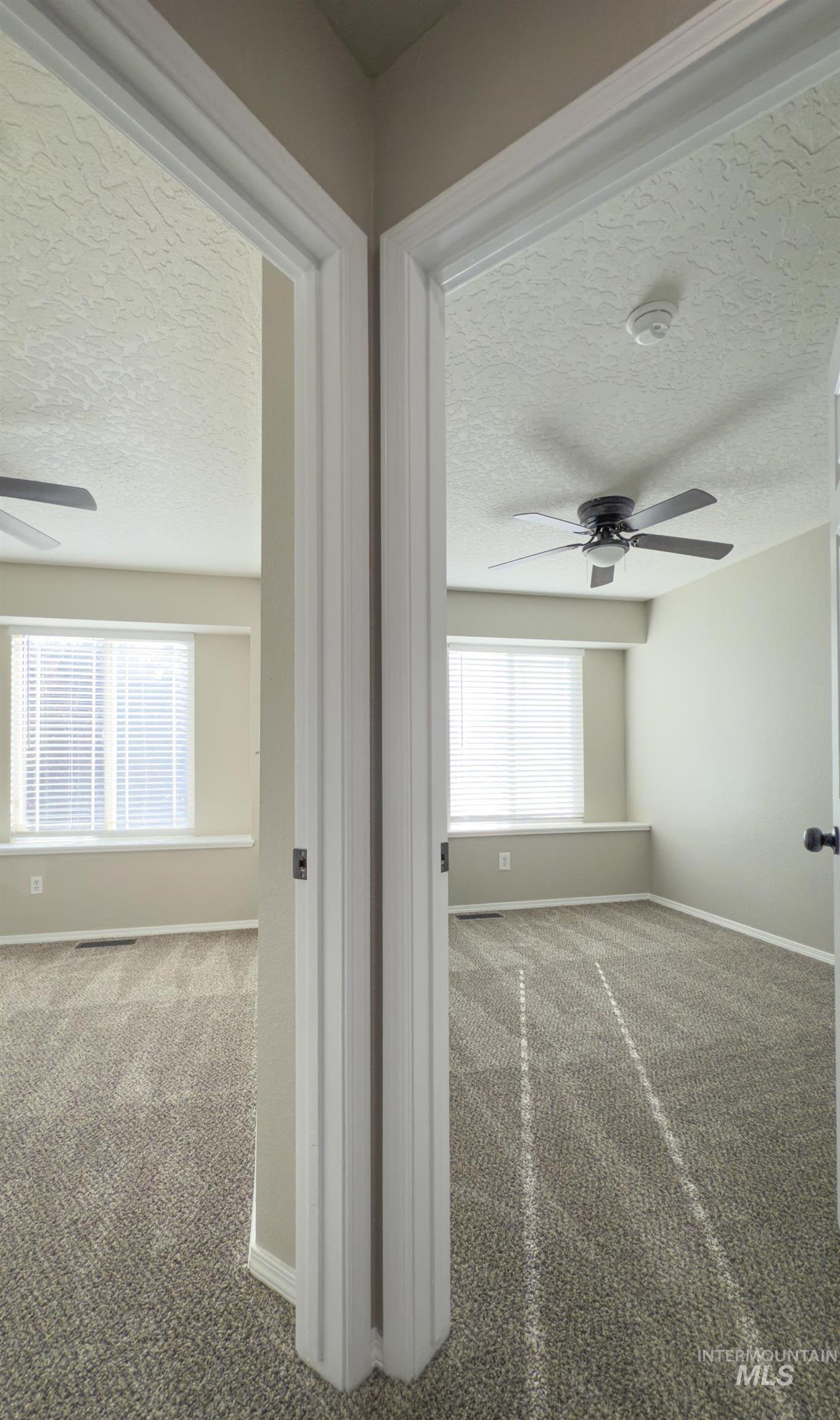 Hall with a textured ceiling and carpet floors