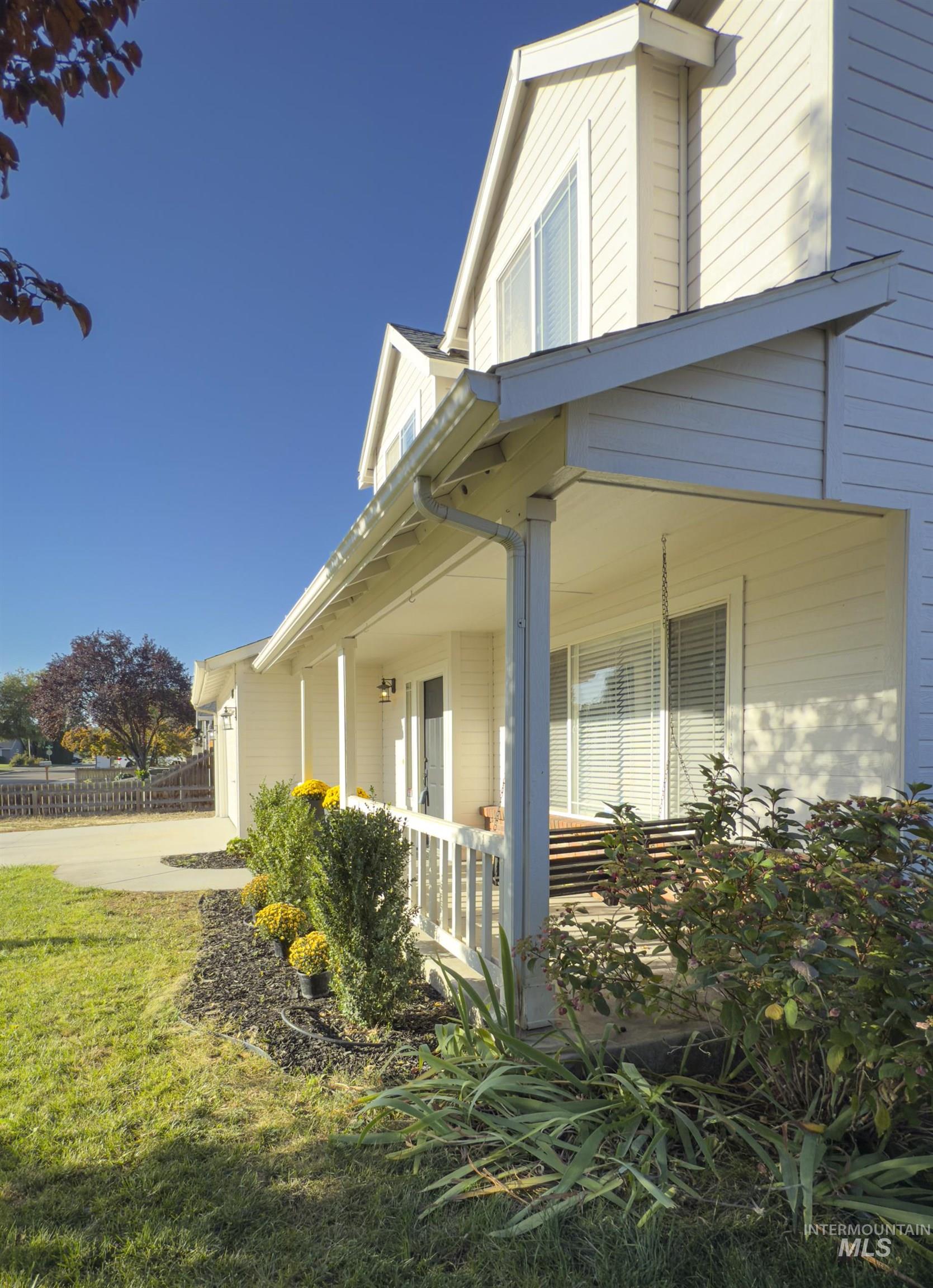 View of home's exterior with a porch, a garage, and driveway