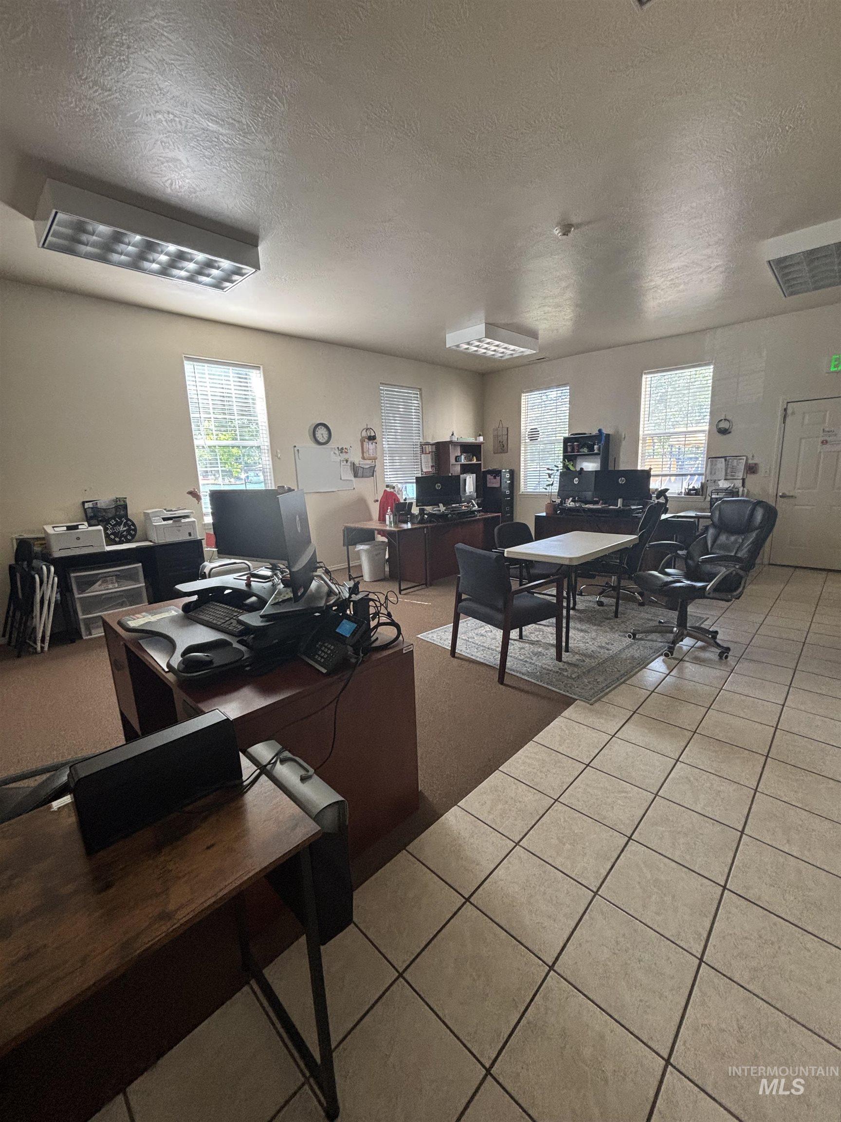 Office area featuring a textured ceiling and light tile patterned floors
