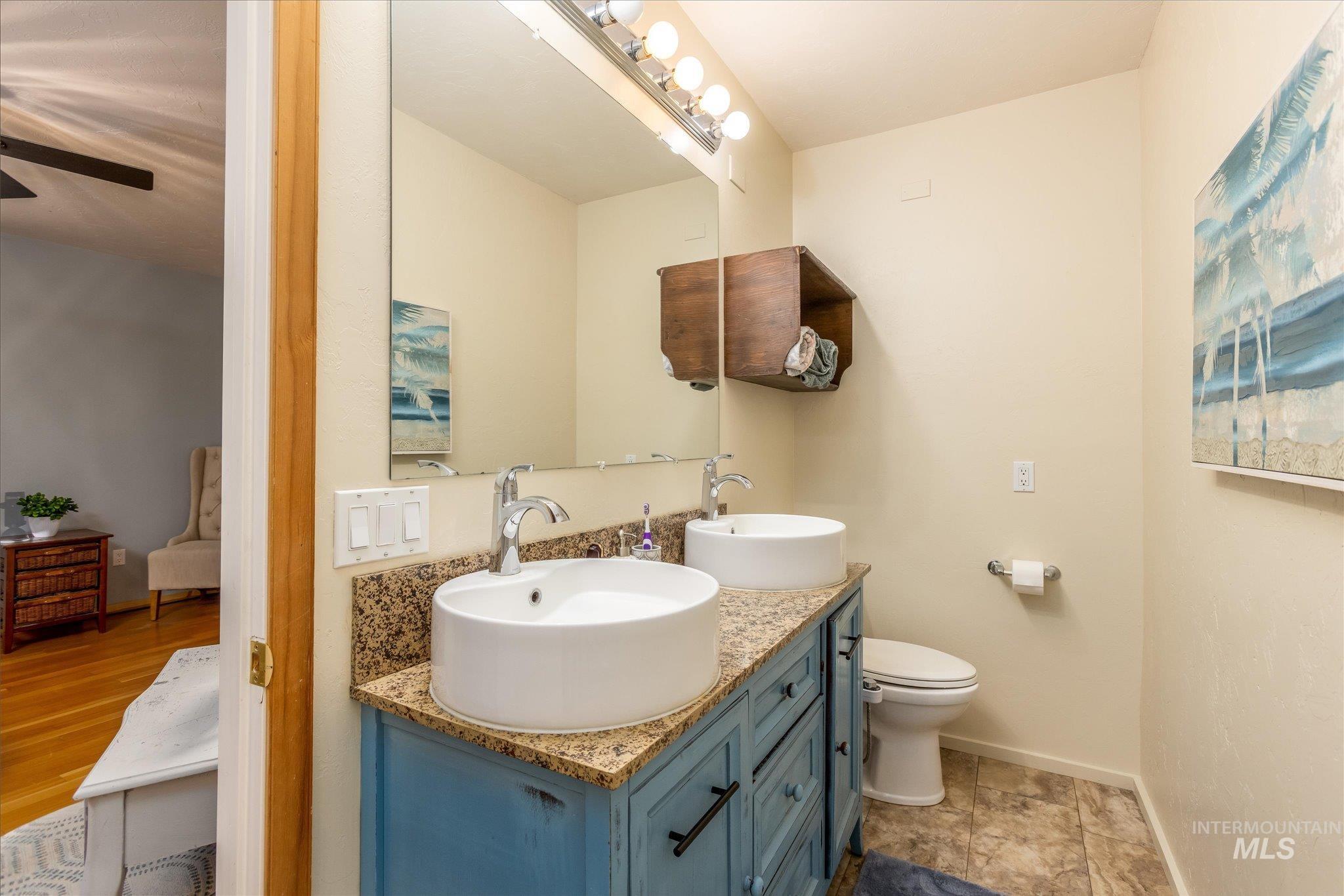 Full bath with baseboards and double vanity