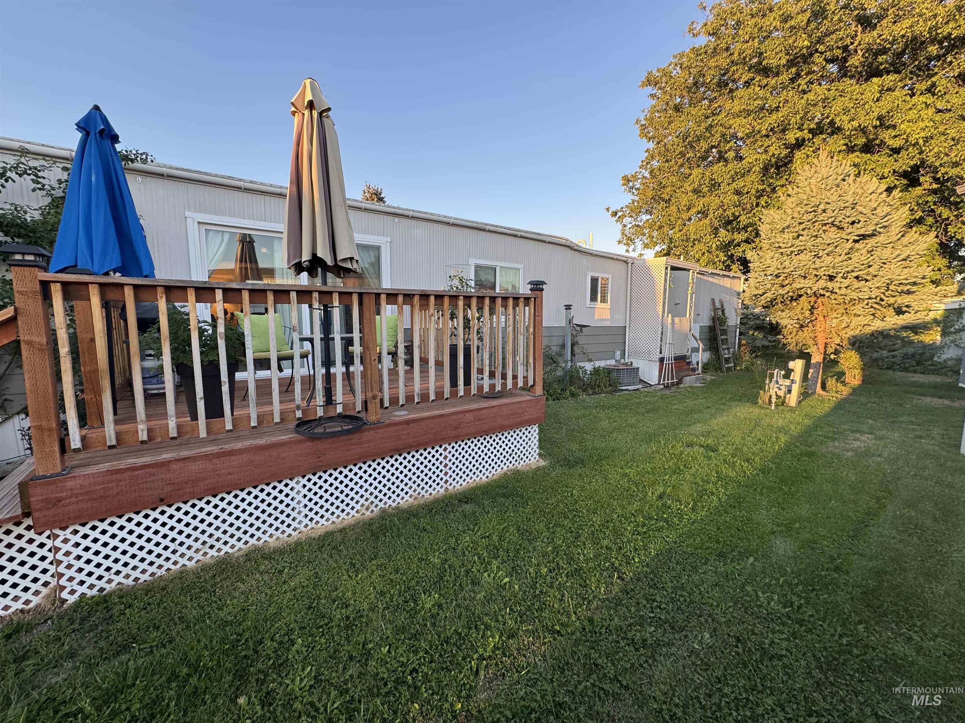 Rear view of house with a lawn and a deck