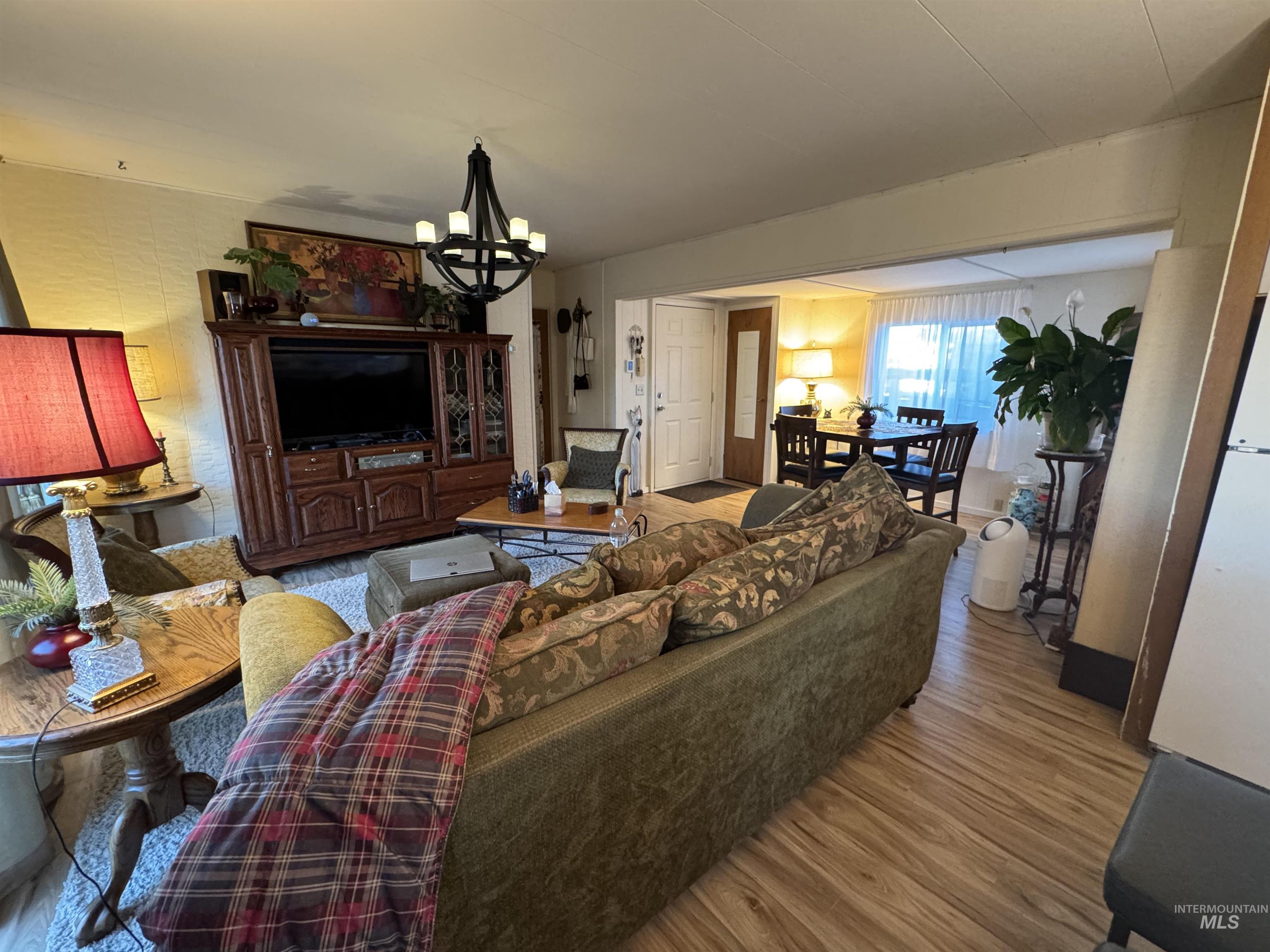 Living area with light wood-style flooring and a chandelier
